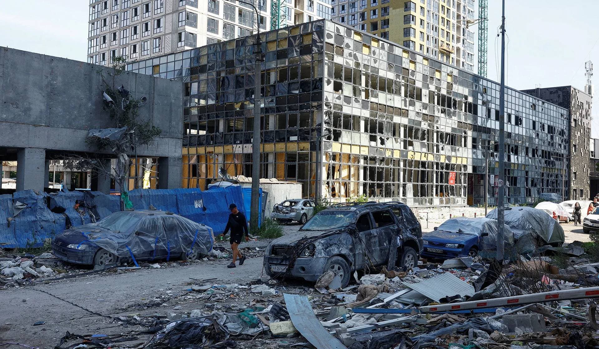 A man walks past vehicles damaged by a Russian missile strike on the previous day in Kyiv, Ukraine, July 7, 2026.