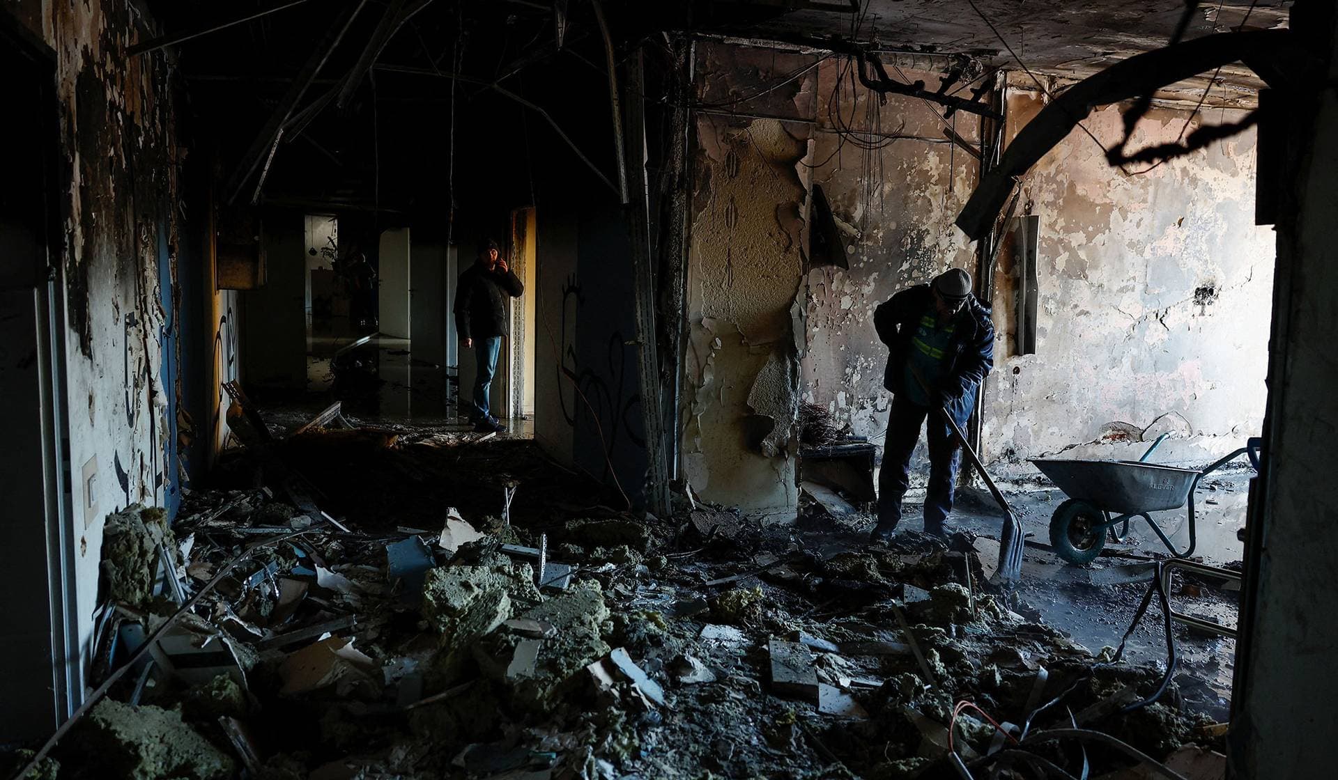 Employees remove debris at the site of a private hospital hit by Russian drone strikes in Kyiv