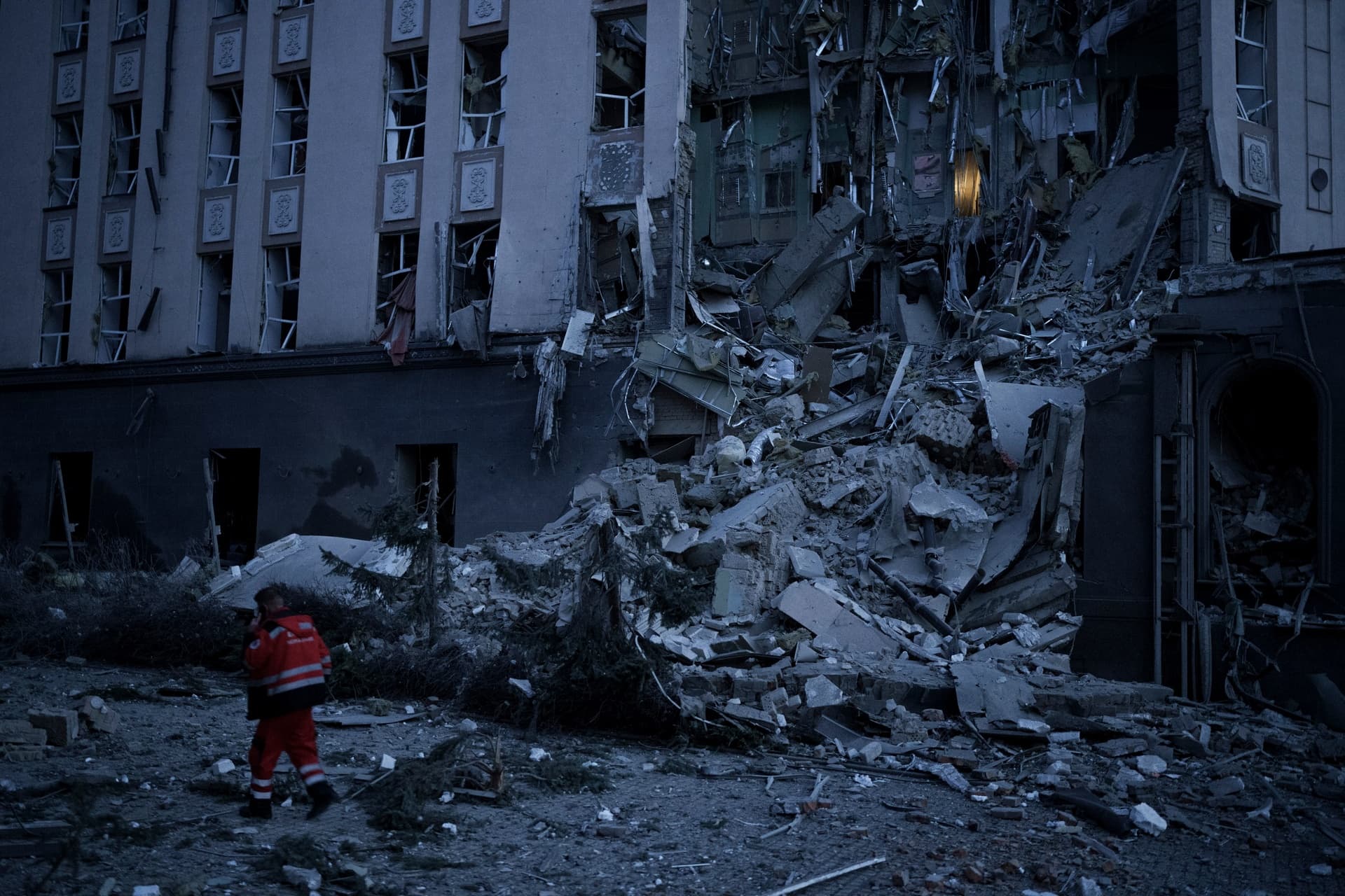 An emergency worker walks in front of a damaged hotel following a Russian attack in Kyiv