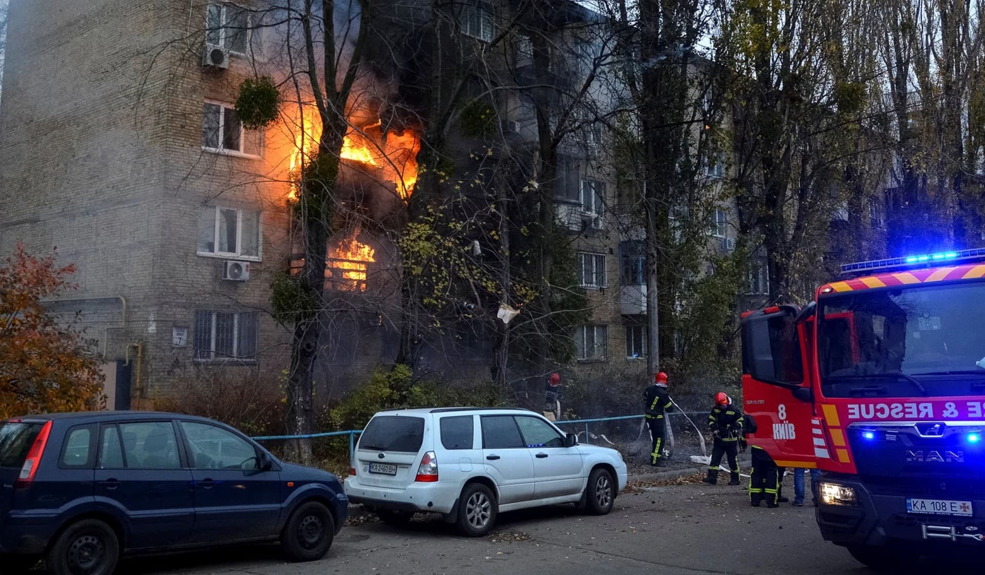 Firefighters work to put out a fire in a residential building hit by a Russian missile strike in Kyiv