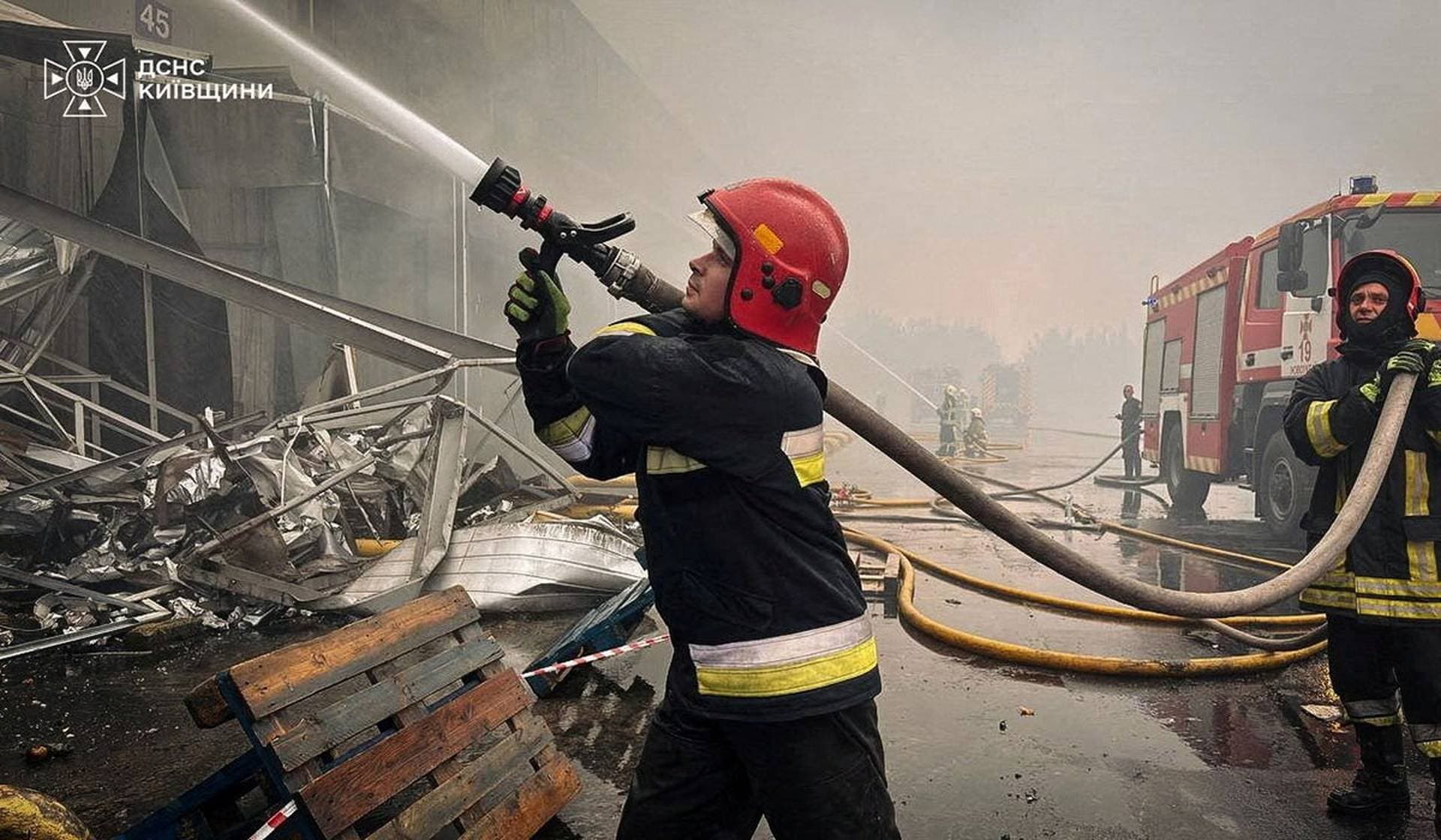 Firefighters work at a site of a Russian drone attack in the Kyiv Region