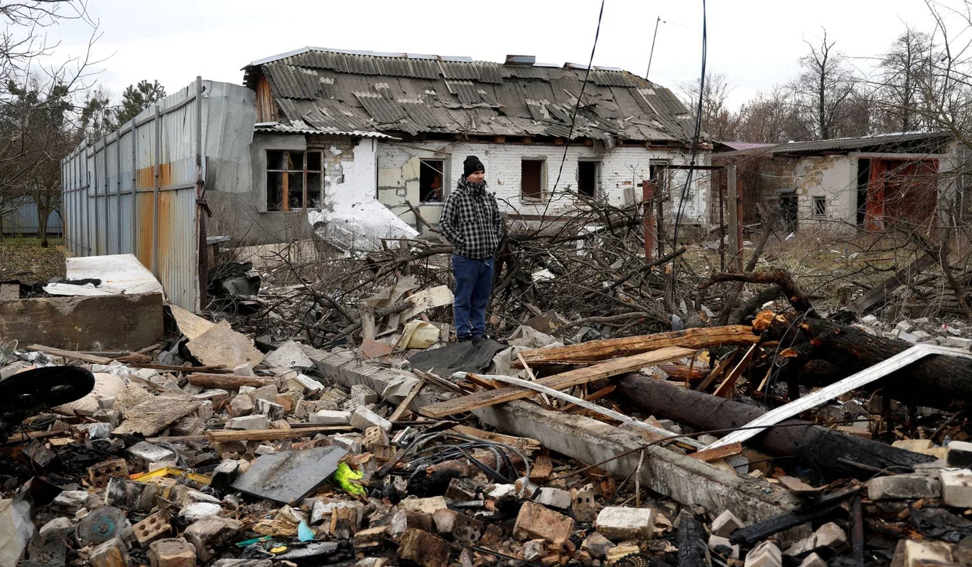 A man stands at a site of a residential house damaged during a Russian missile strike in Kyiv