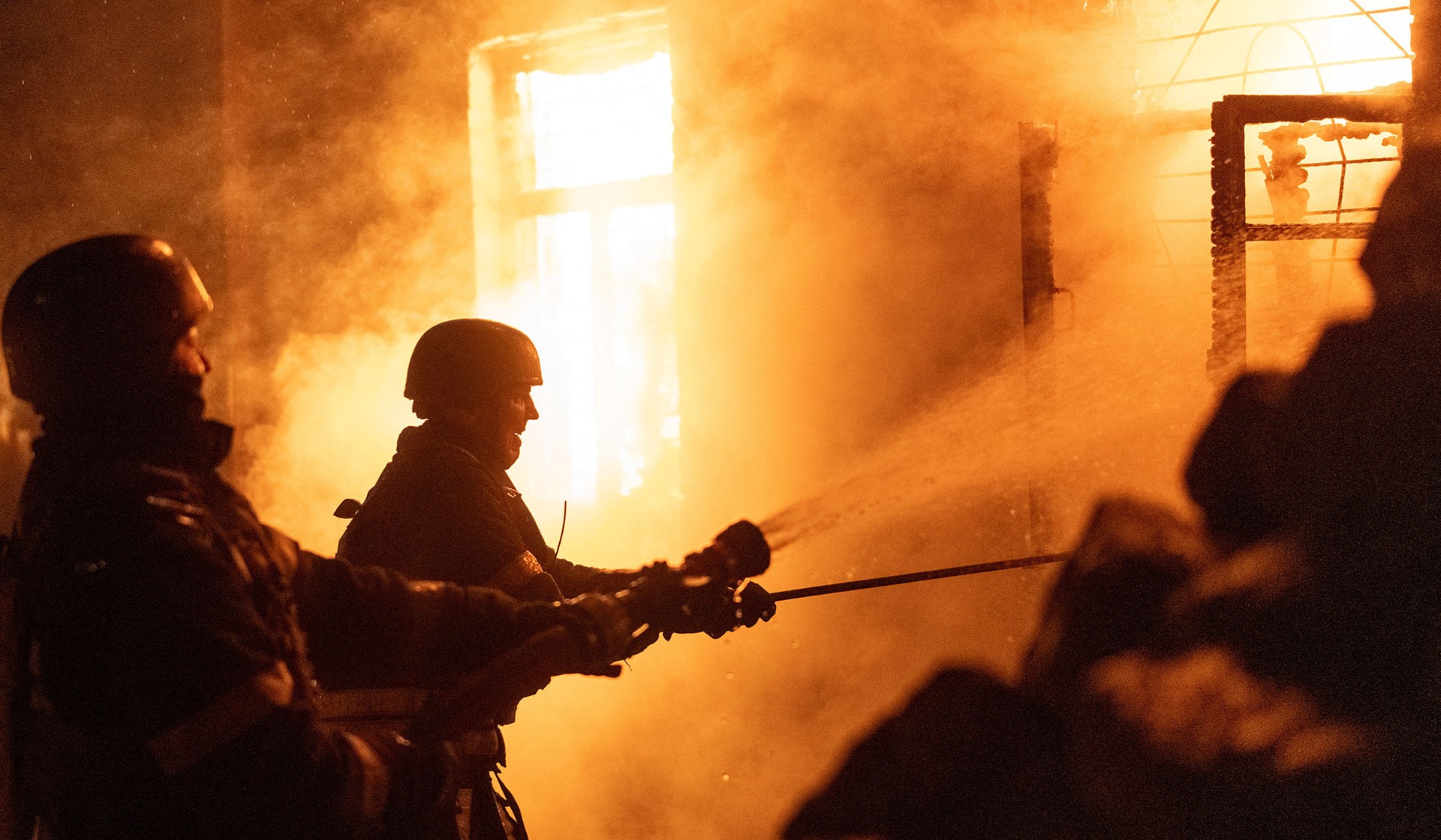 Firefighters work at a site of a private house hit by  a Russian drone strike in Kyiv