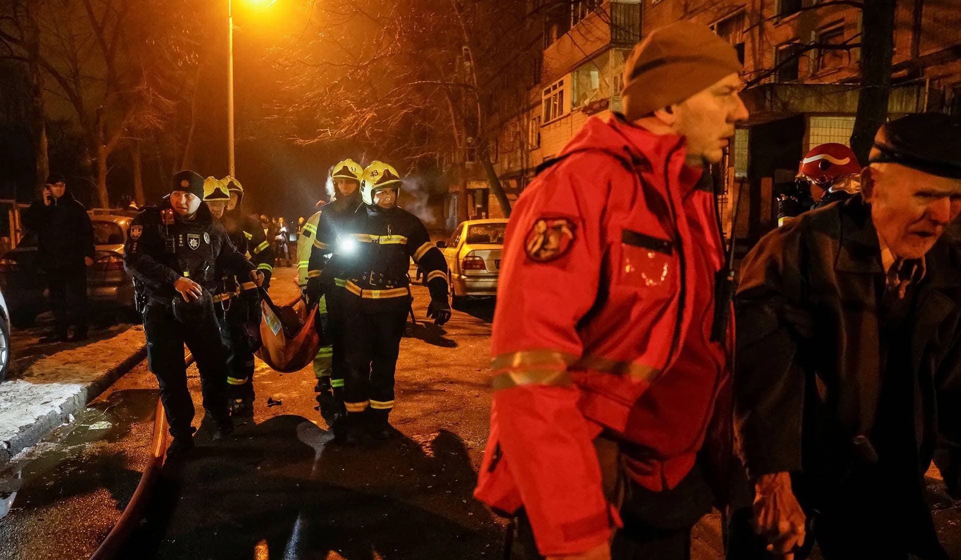 Emergency staff carry a wounded local resident at a site of an apartment building damaged during a Russian missile strike in Kyiv