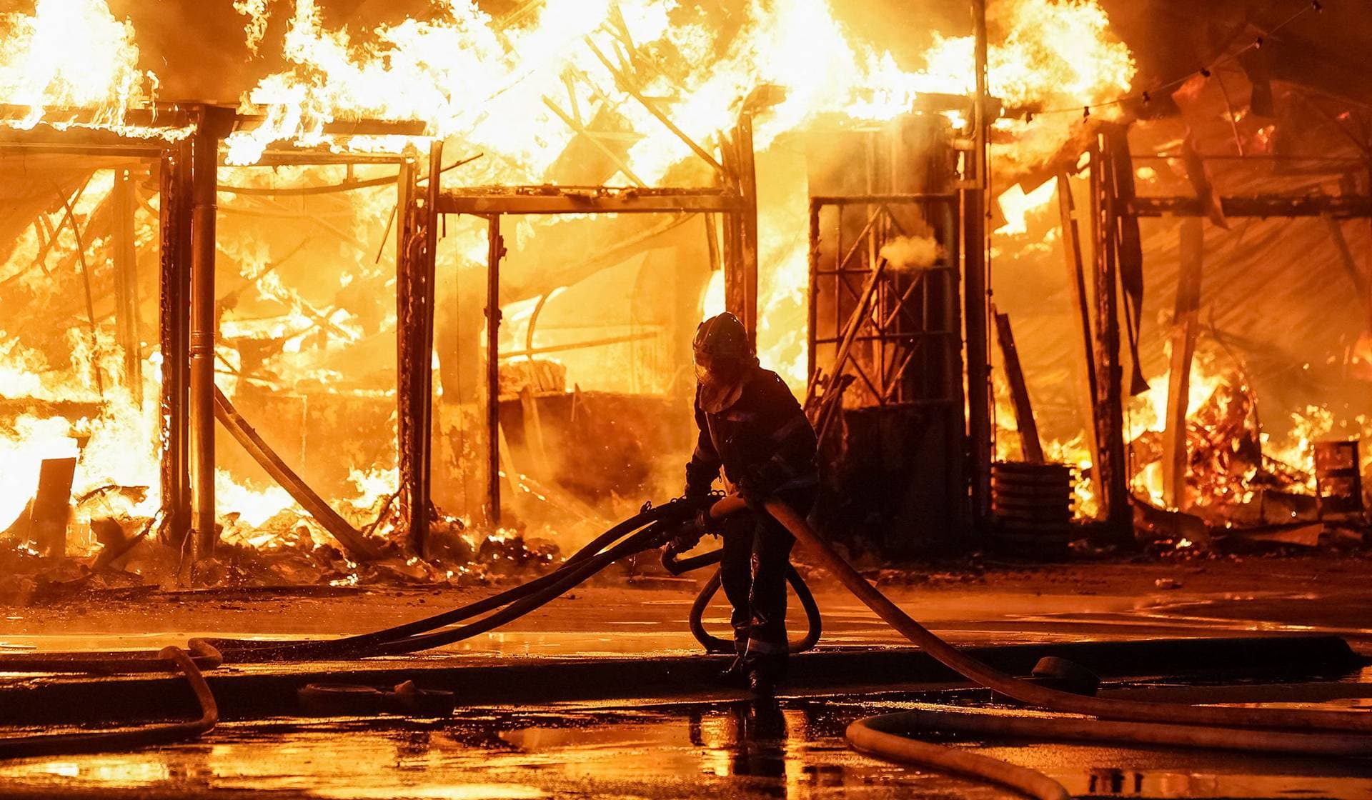 A firefighter works at a site of a book market hit by a Russian missile strike in Kyiv