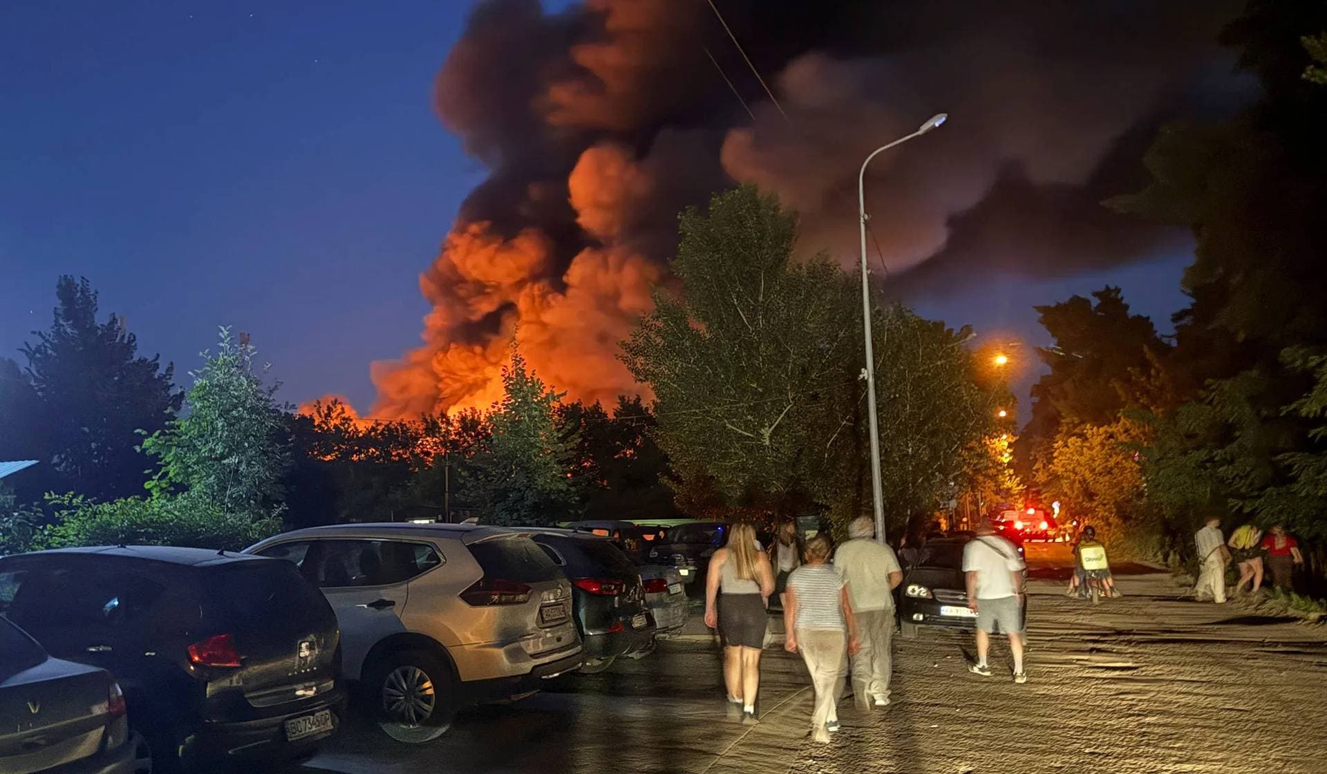Residents walk at the site of a Russian missile strike in Kyiv