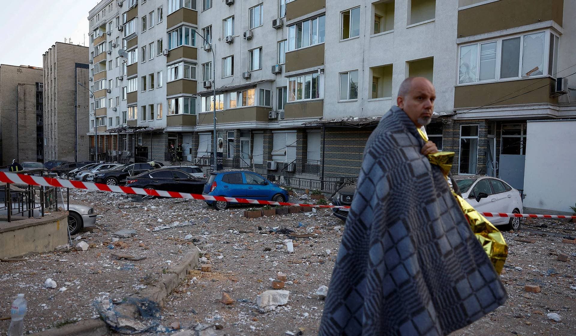 A man stands next to his apartment building heavily damaged during a massive Russian drone strike in Kyiv