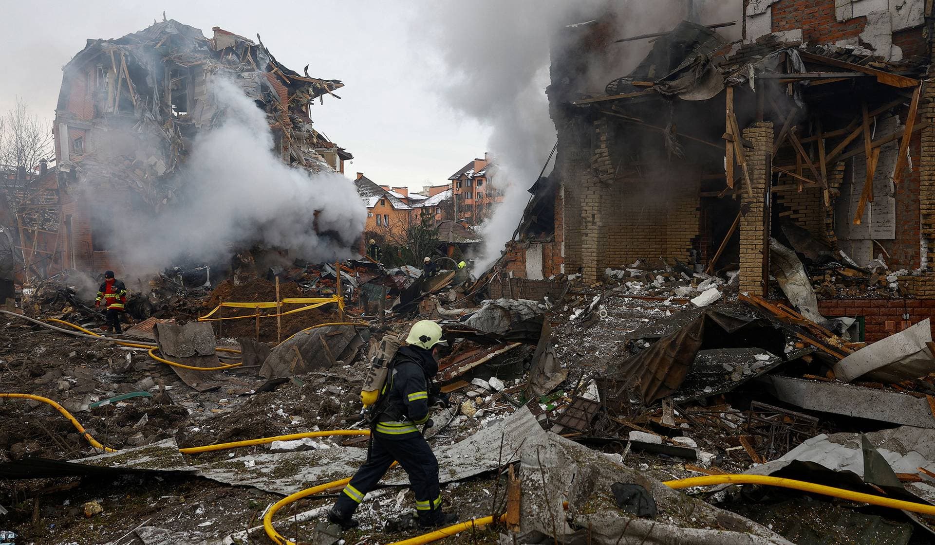 Firefighters work at the site of a residential building damaged during Russian drone and missile strikes in Kyiv
