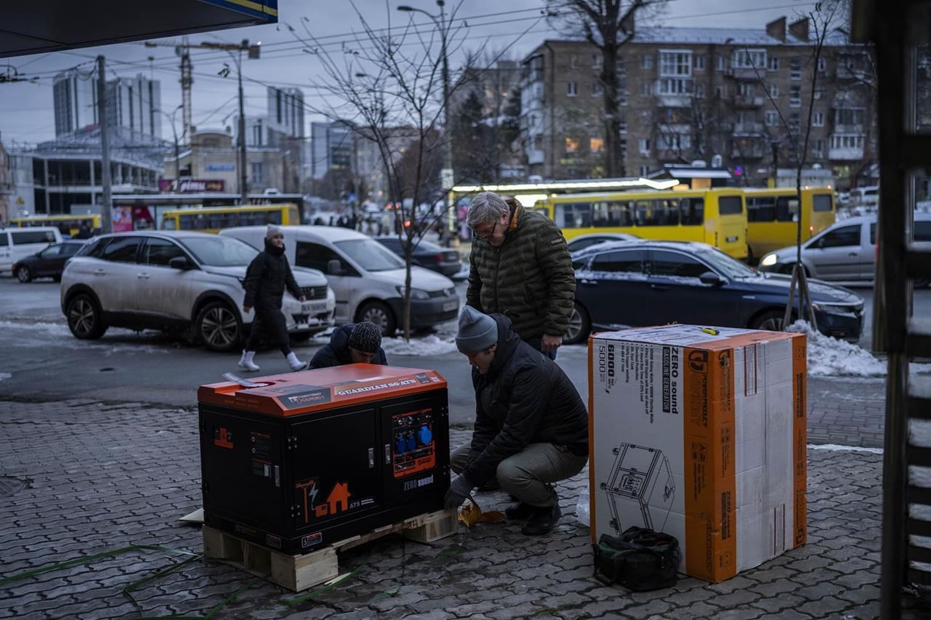 Ukrainians unpack a power generator before installing it at a bank branch in Kyiv