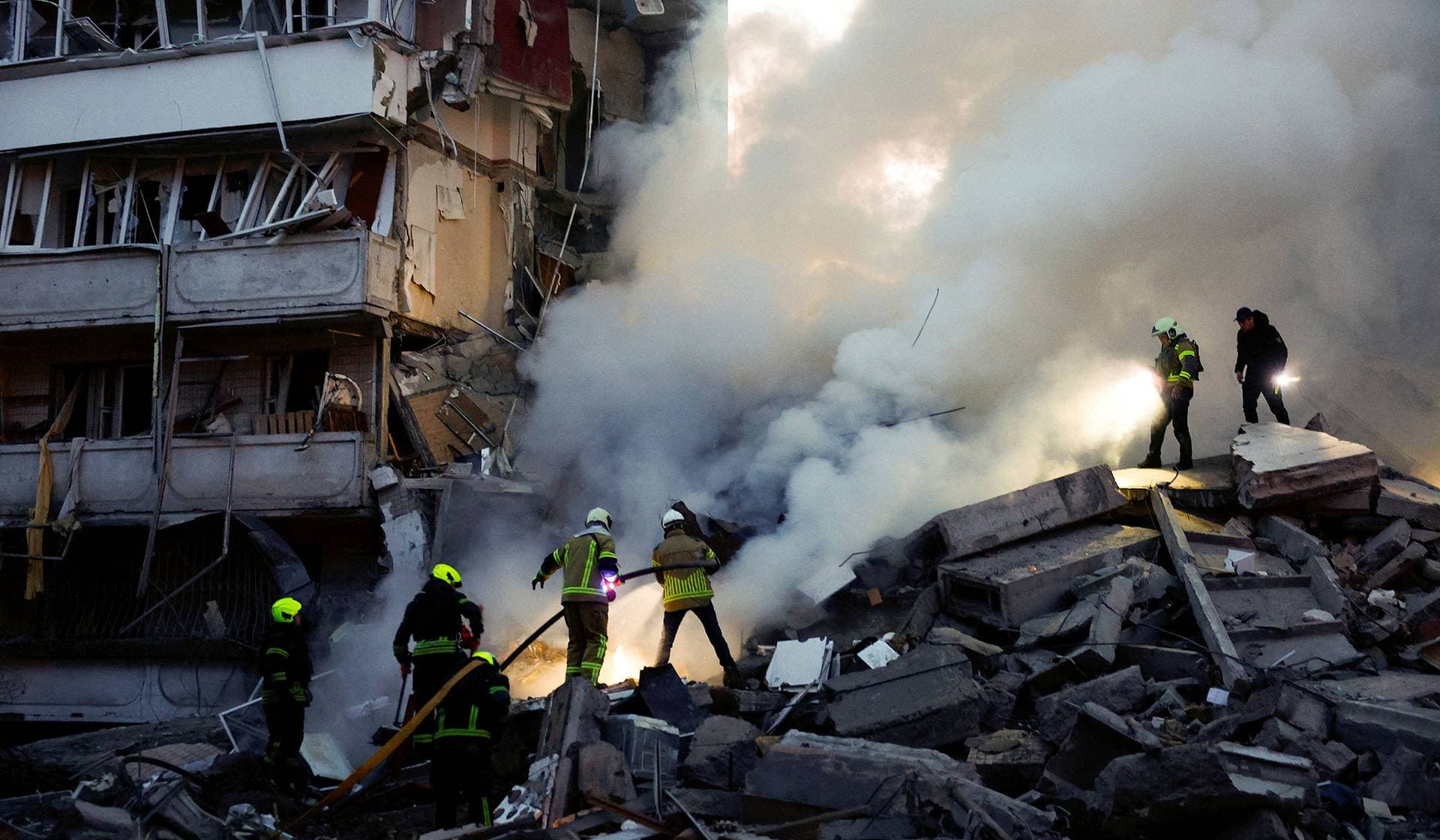 Rescuers search for people under the debris at the site of an apartment building damaged during Russian missile and drone strikes in Kyiv