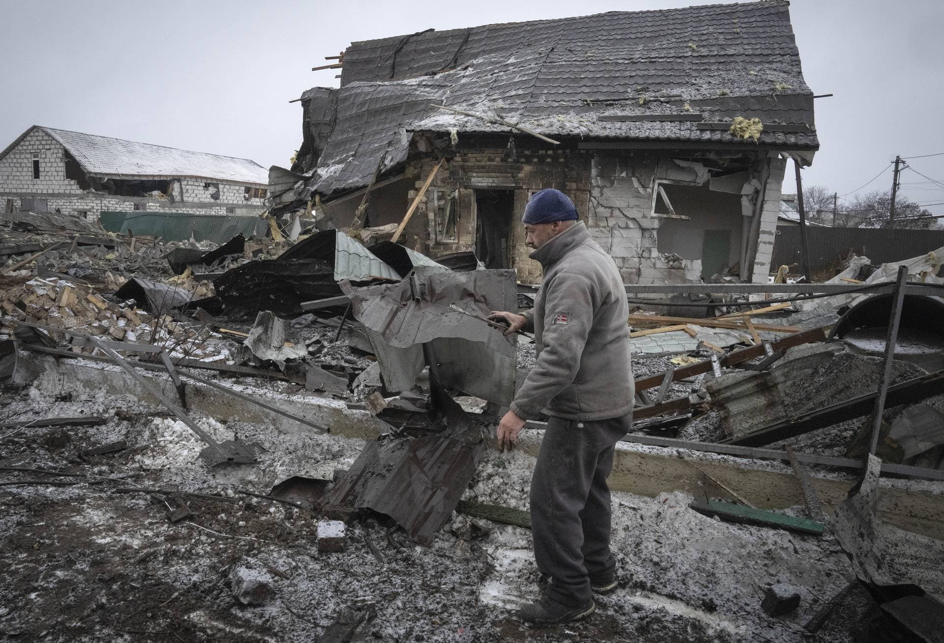 A local resident sorts out debris at the site of a private house ruined in the Russian missile attack in Kyiv