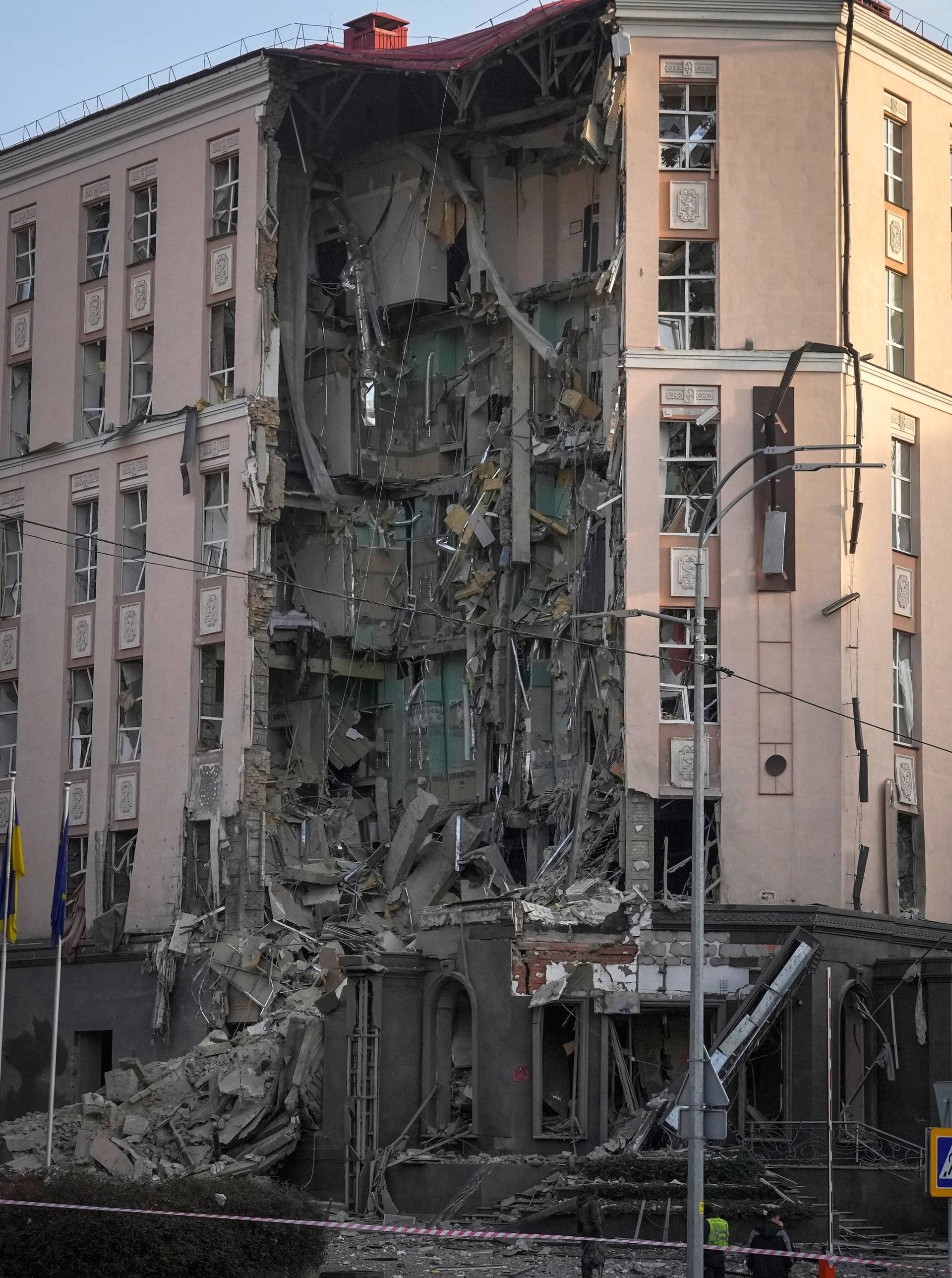 Police stand in front of damaged hotel at the scene of Russian shelling in Kyiv, Ukraine