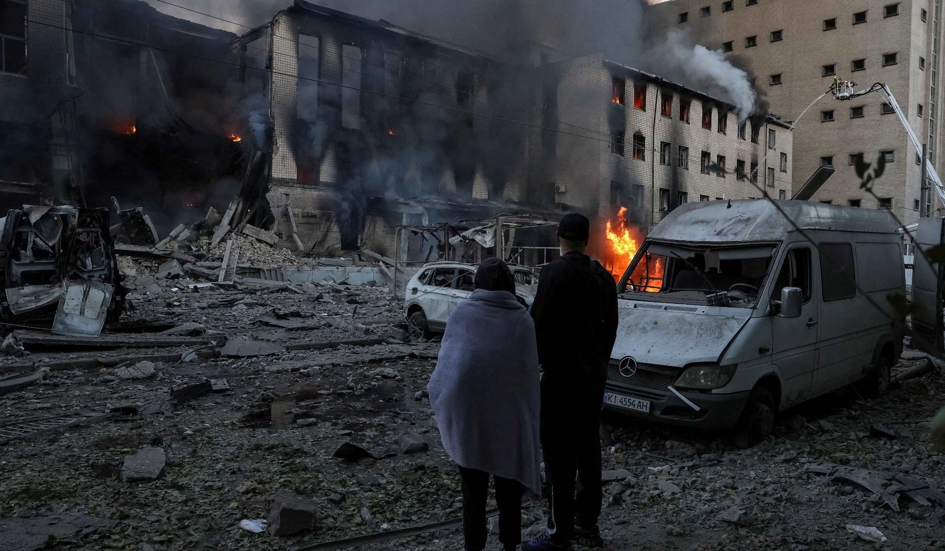 Residents stand at the site of a Russian missile strike in Kyiv