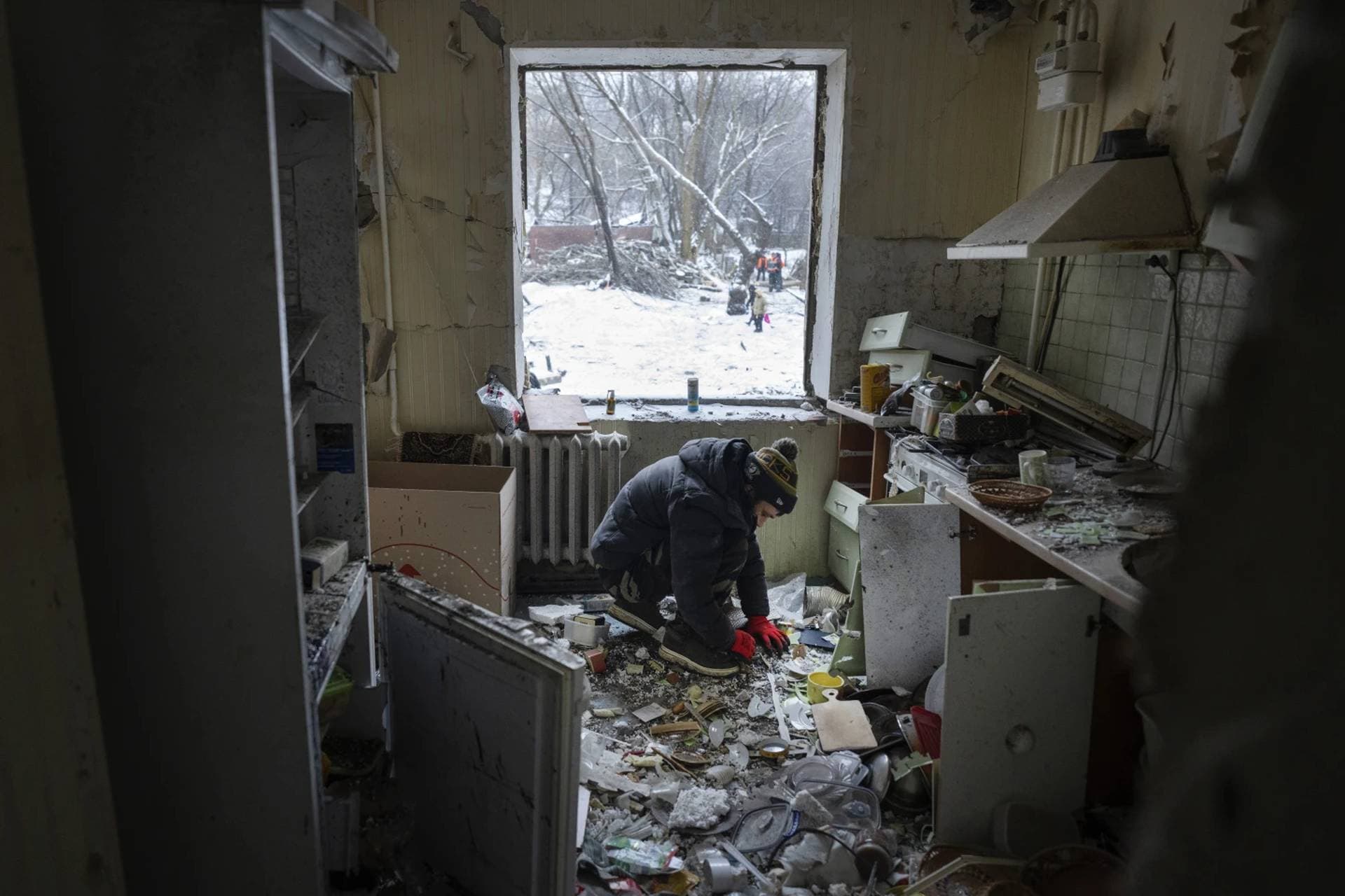 A man clears debris in his kitchen in an apartment building damaged after Tuesday’s Russian missile attack in Kyiv