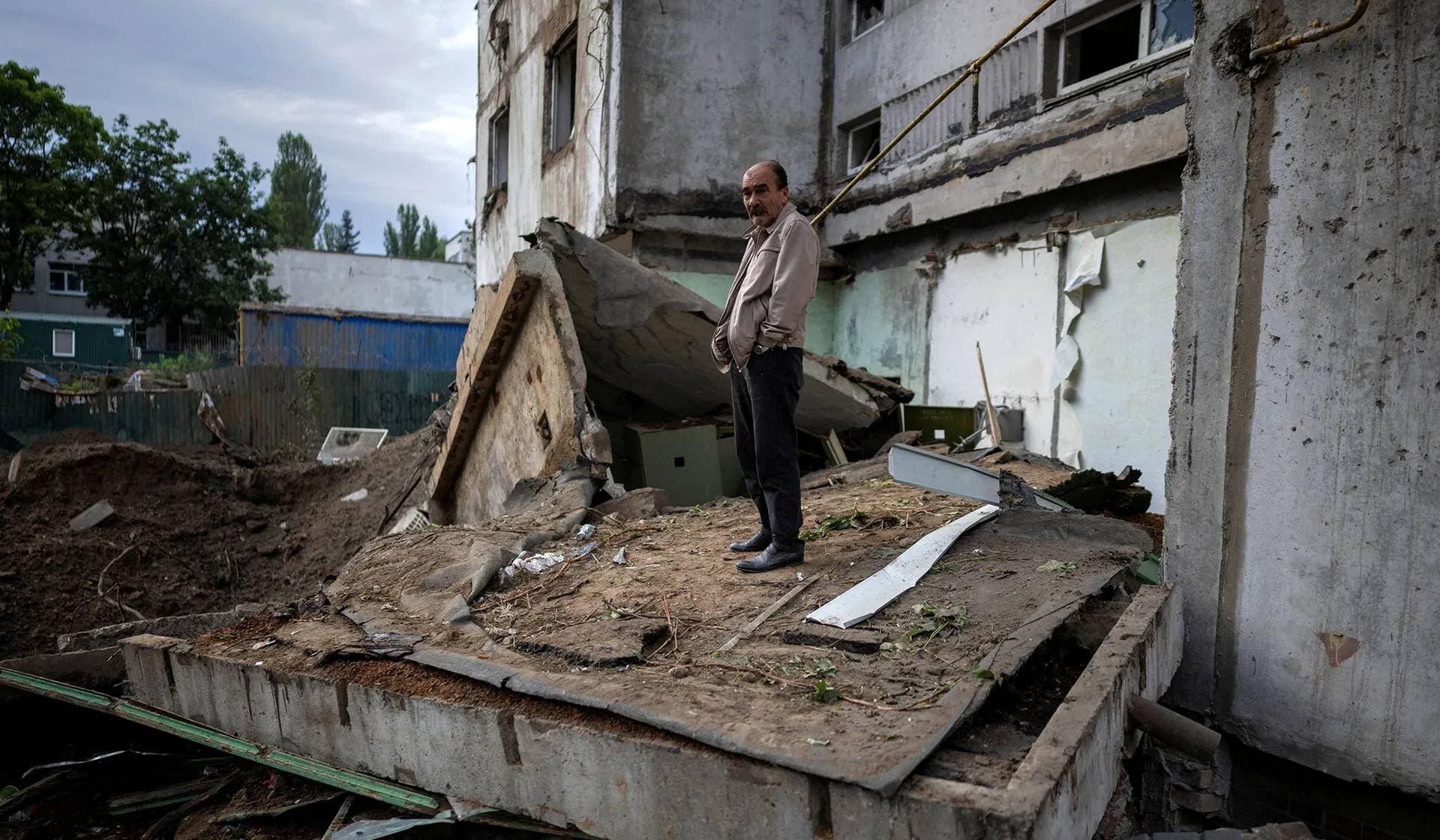 A resident stands outside his apartment building heavily damaged during Russian missile and drone strikes in Kyiv