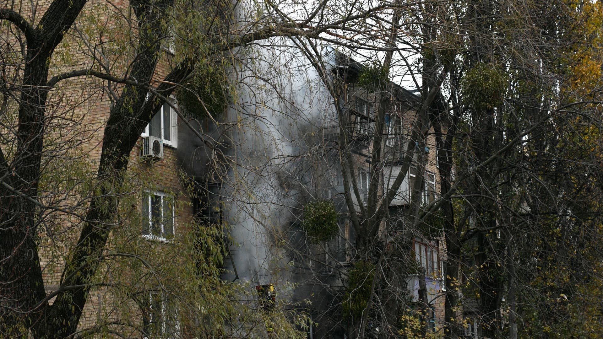 Ukrainian State Emergency Service firefighters work to extinguish a fire at the scene of a Russian shelling in Kyiv