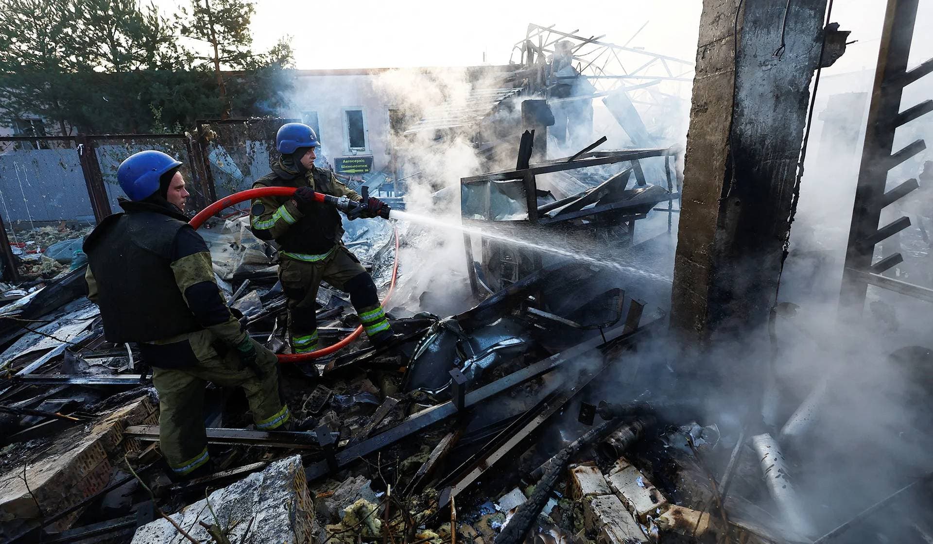 Firefighters work at a site in a residential area damaged during a Russian missile strike in Kyiv