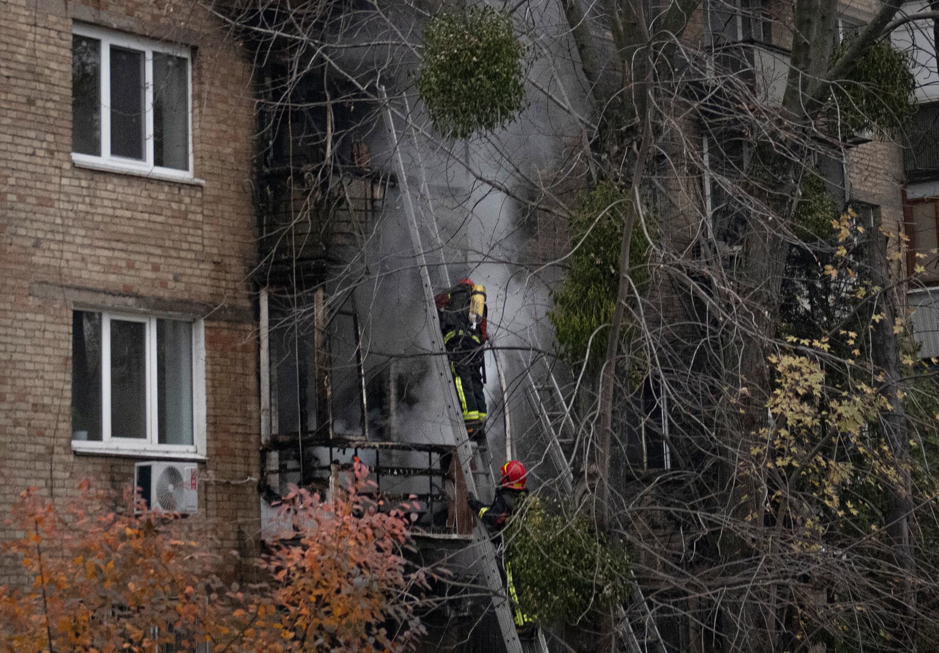 Ukrainian State Emergency Service firefighters work to extinguish a fire at the scene of a Russian shelling in Kyiv