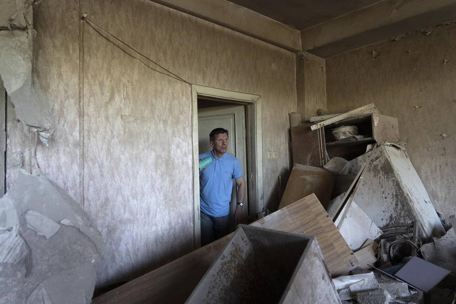 Vladimir Golubenko looks at his office damaged by a drone during a night attack, in Kyiv