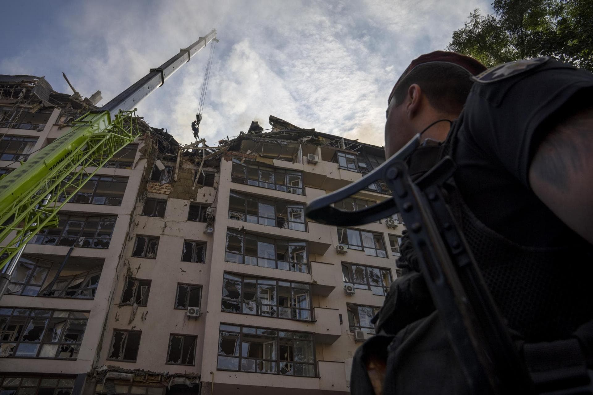 Servicemen work at the scene at a residential building following explosions, in Kyiv