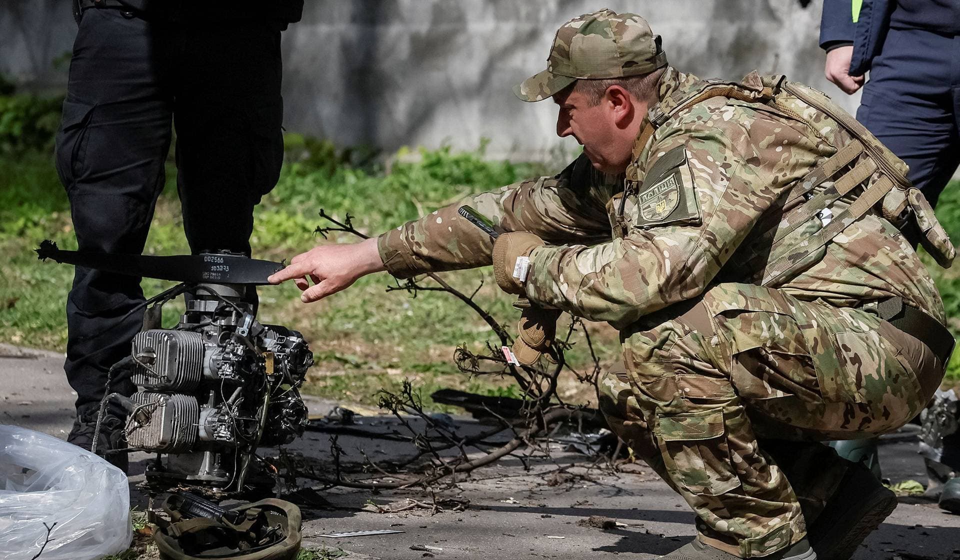 A police expert inspects the engine of a Russian drone at the site of a Russian drone strike in Kyiv