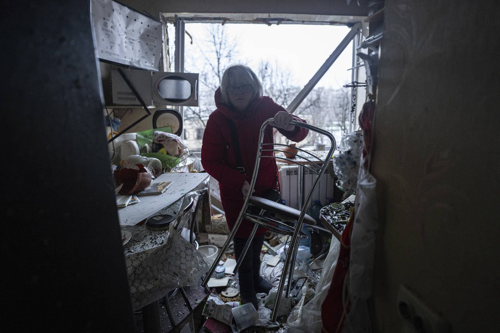 A woman cleans her damaged apartment after a Russian attack at a residential neighbourhood in Kyiv