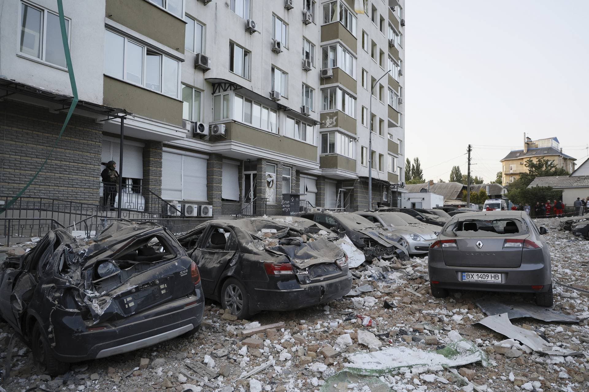 Damaged cars are parked in the yard of a multi-story apartment building which was damaged in a relentless wave of bombardments targeting in Kyiv