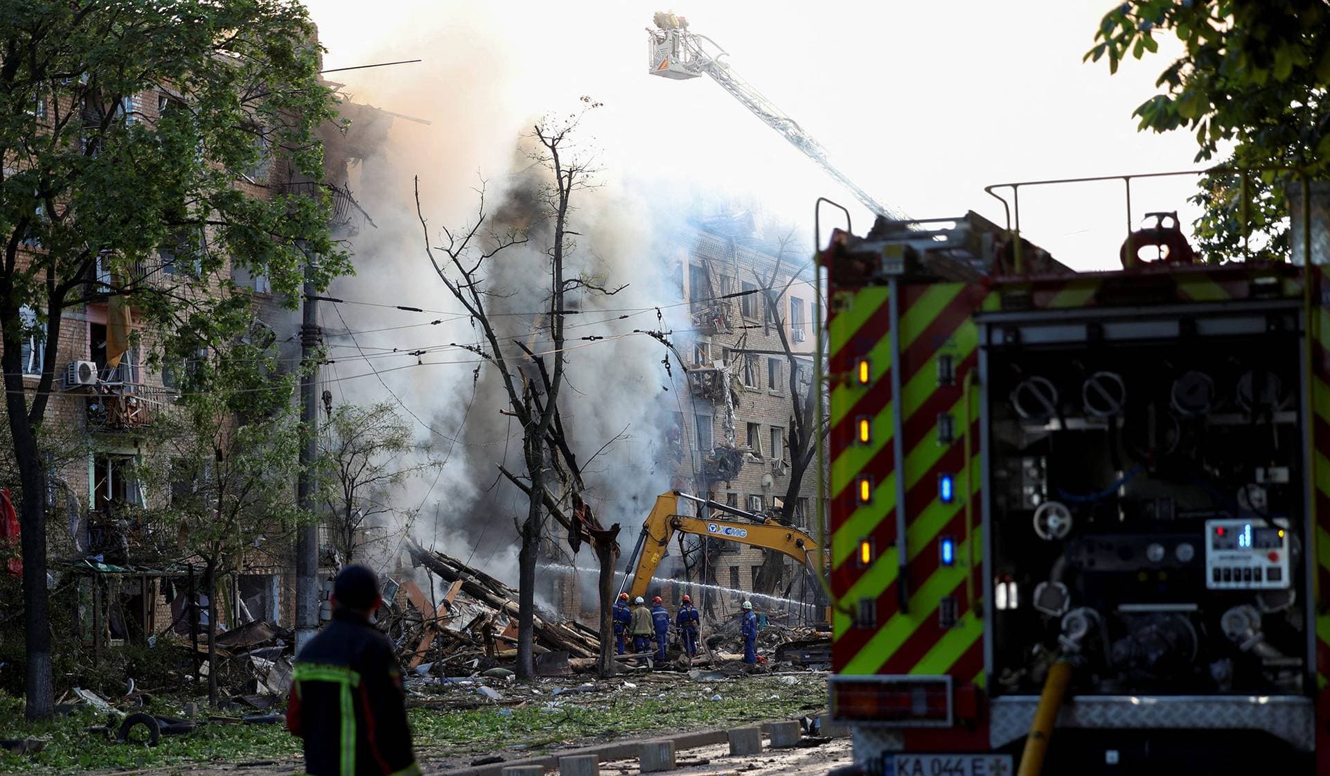 Firefighters work at the site of an apartment building damaged during a Russian missile and drone strike in Kyiv