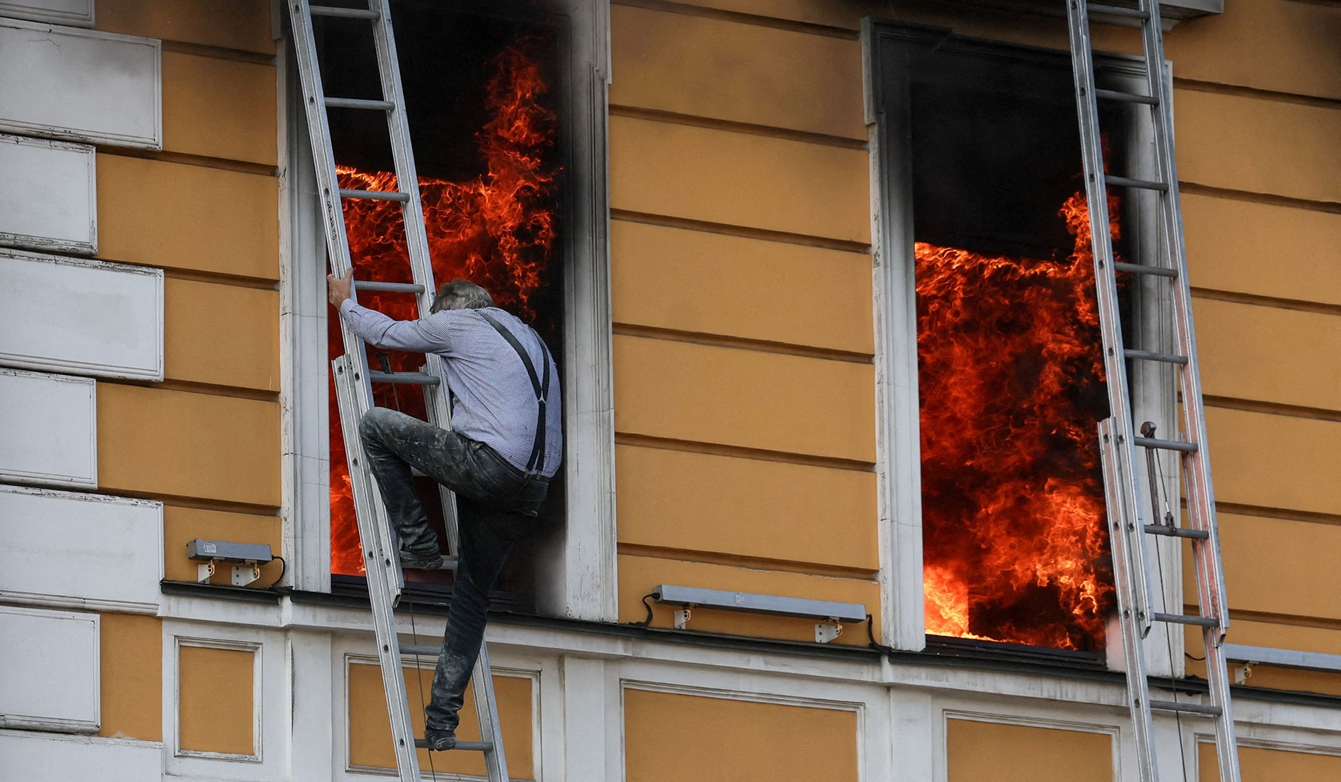 Ihor Malchevsky, 69, a deputy department head at Ukraine's National Academy of Sciences, tries to evacuate an administrative building hit by a Russian jet-powered drone strike in Kyiv
