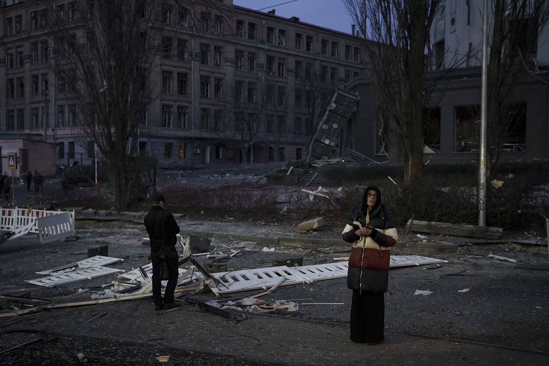 People stand outside a damaged hotel following a Russian attack in Kyiv