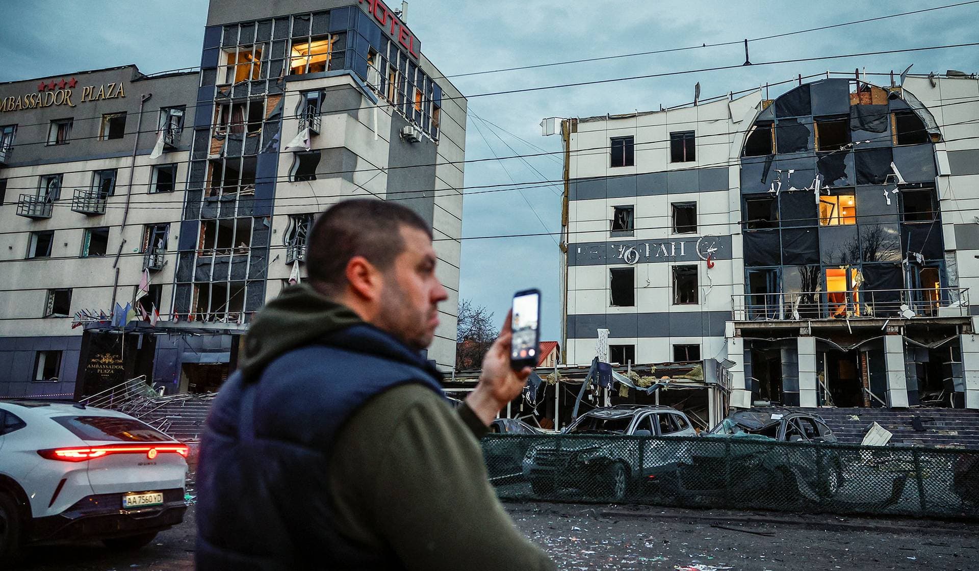 A man records using his mobile phone near the site of a Russian missile strike in Kyiv