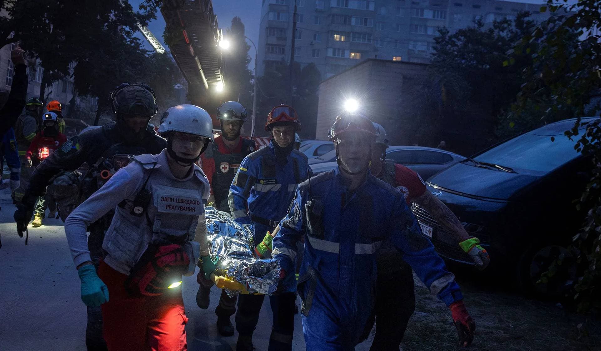First responders carry a person from an apartment building, which was heavily damaged during Russian missile and drone strikes in Kyiv