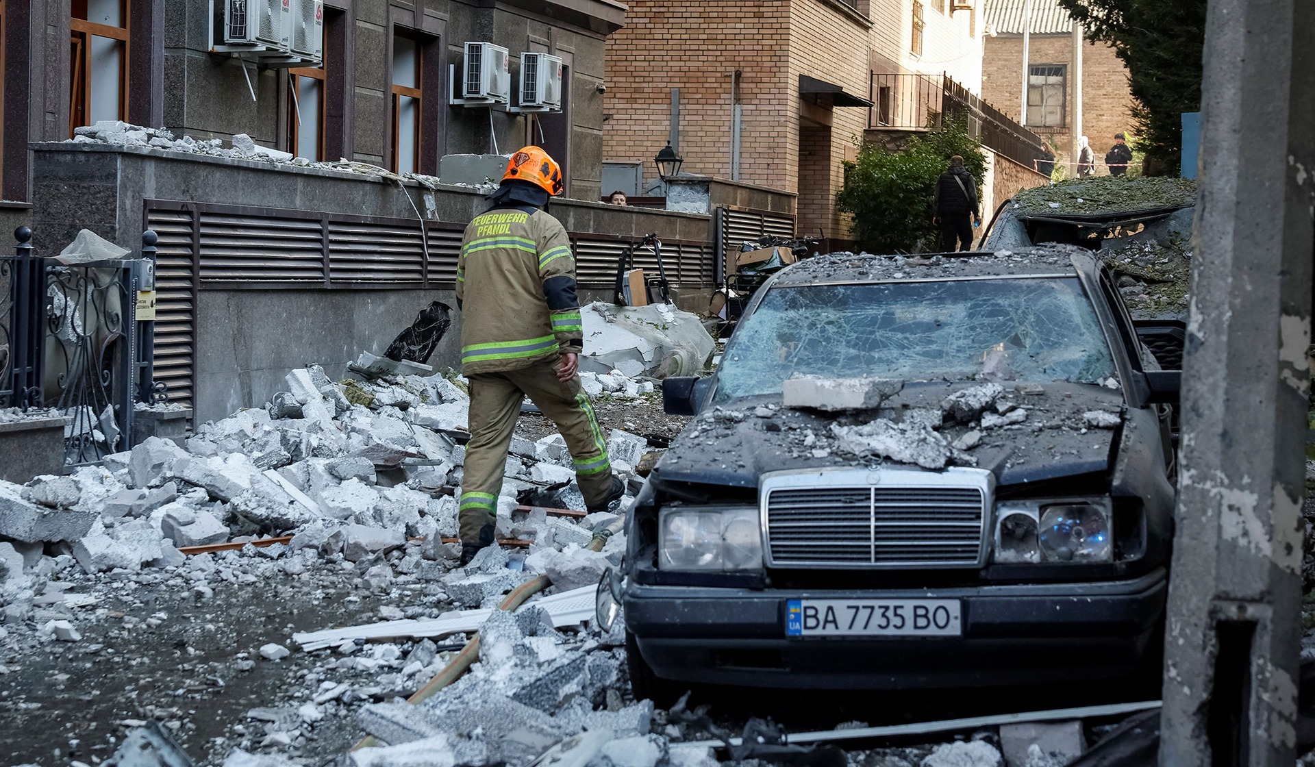 A firefighter walks at the site of a Russian drone strike in Kyiv