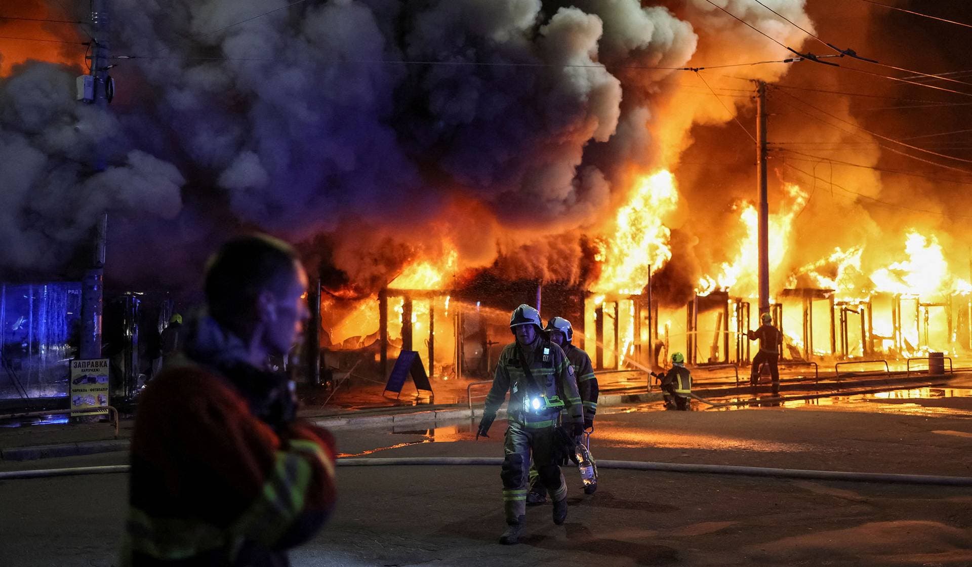 Firefighters work at a site of a book market hit by a Russian missile strike in Kyiv