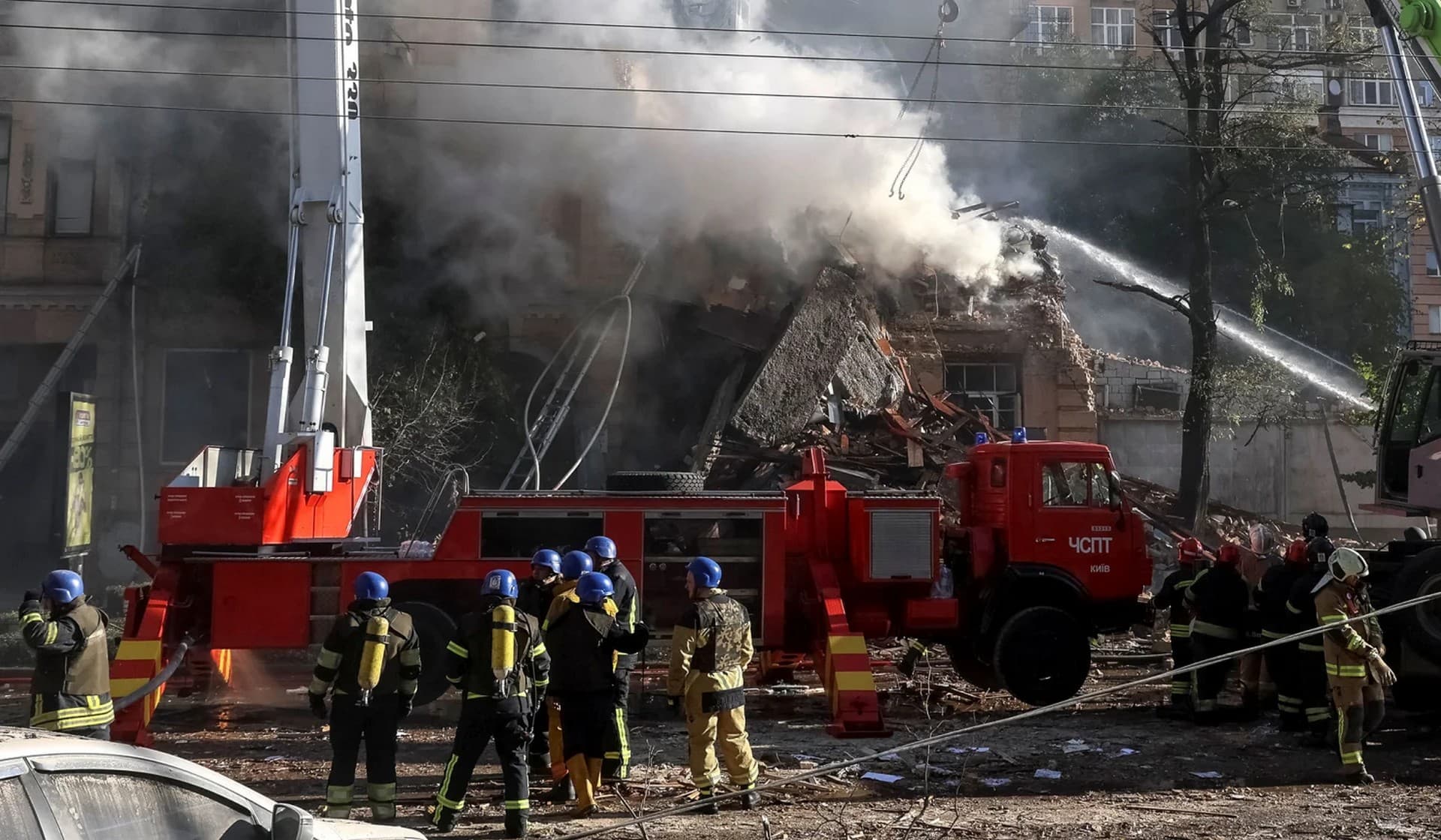 Firefighters work to put out a fire in a residential building destroyed in a strike by Russian drones in Kyiv