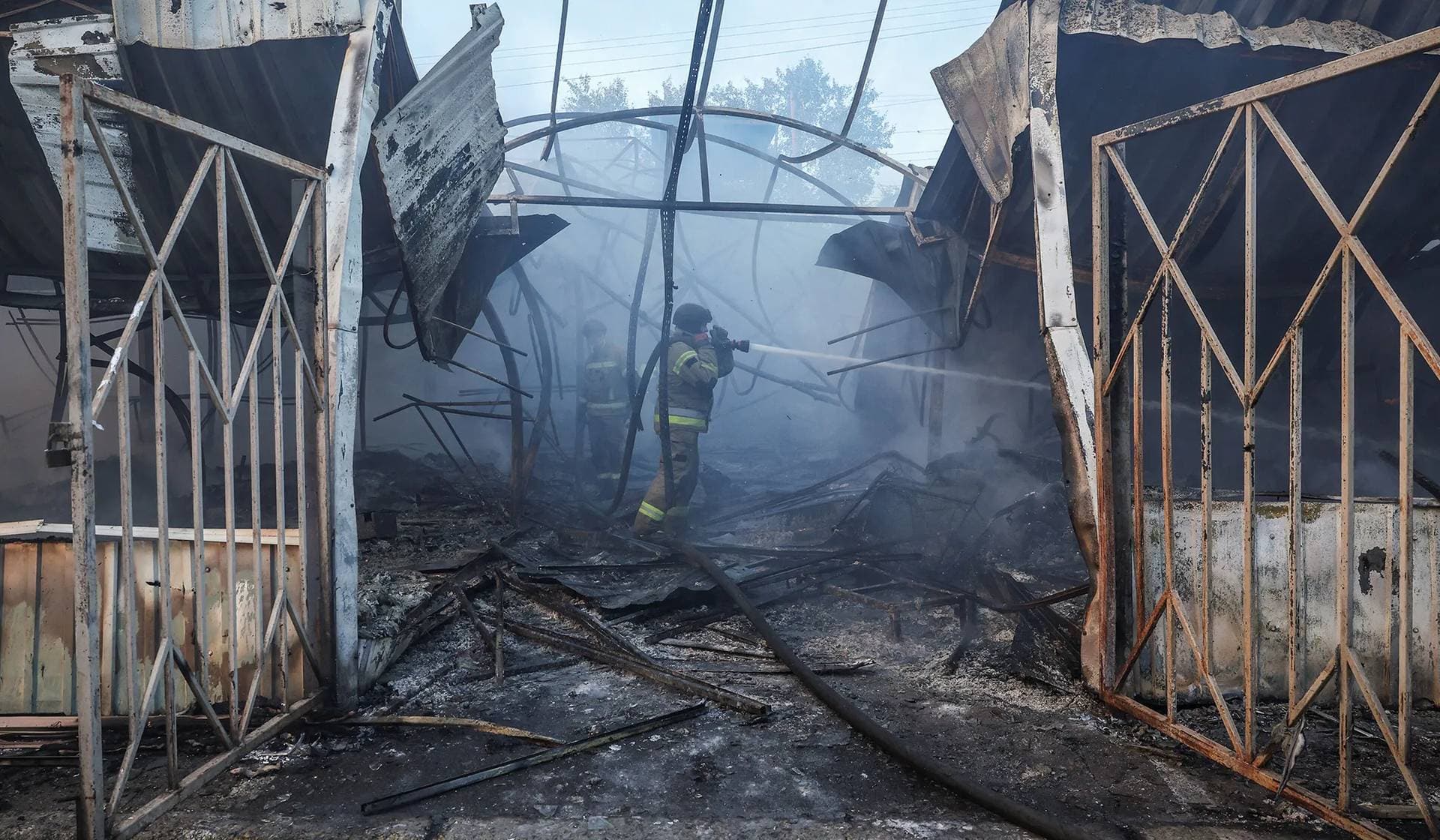 Firefighters work at a market damaged during Russian missile and drone strike in Kyiv