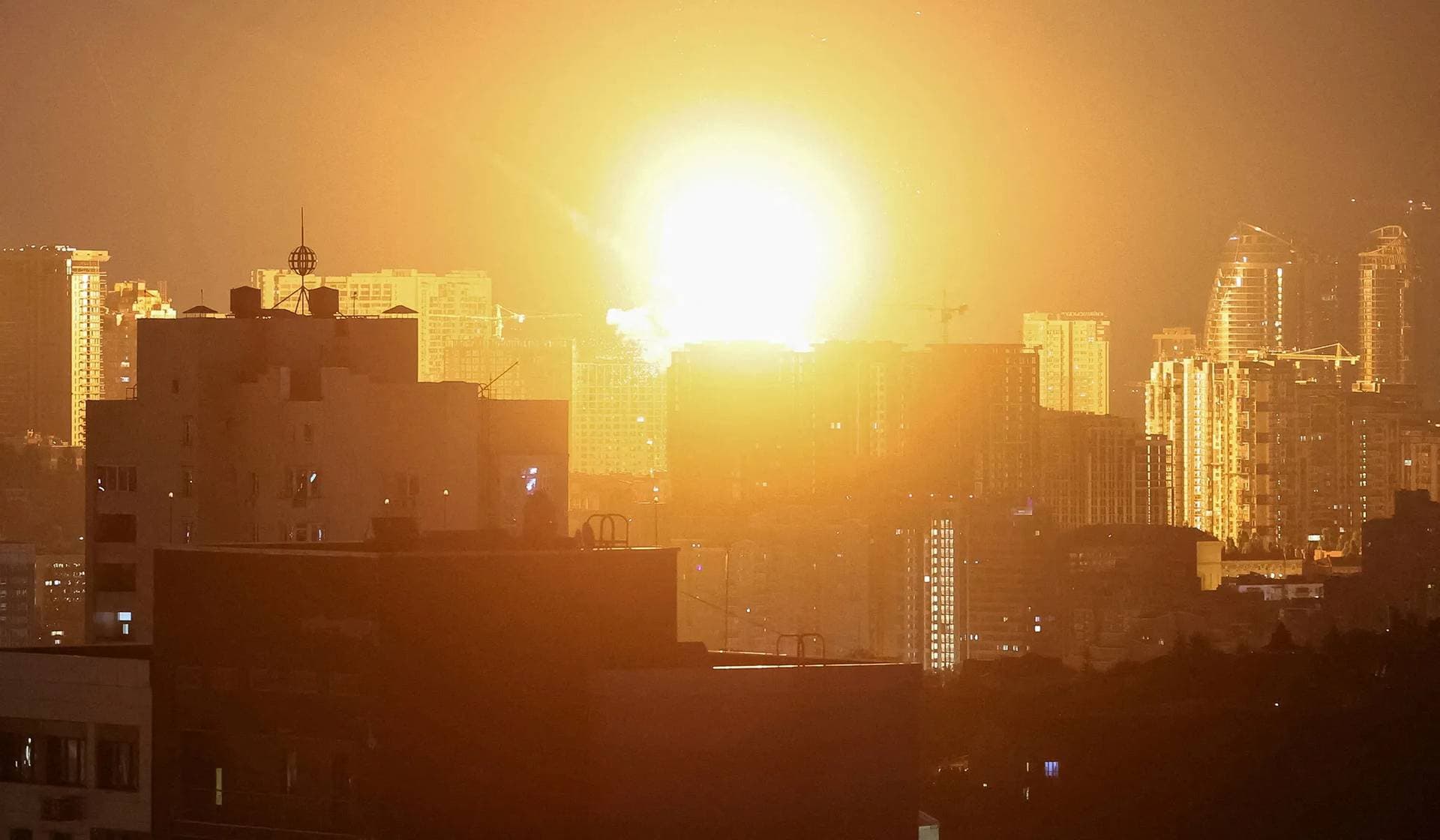 An explosion lights up the sky over the city during a Russian missile and drone strike in Kyiv