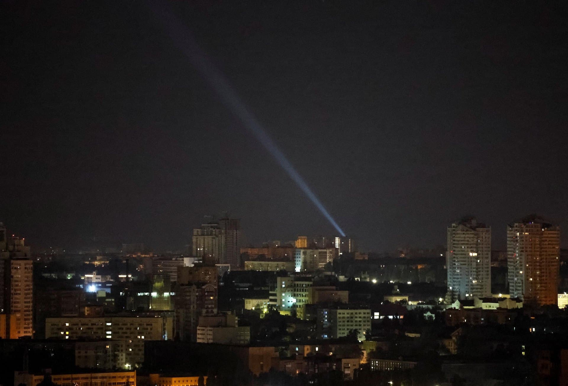 Ukrainian forces use a searchlight to scan the sky during a Russian drone strike in Kyiv