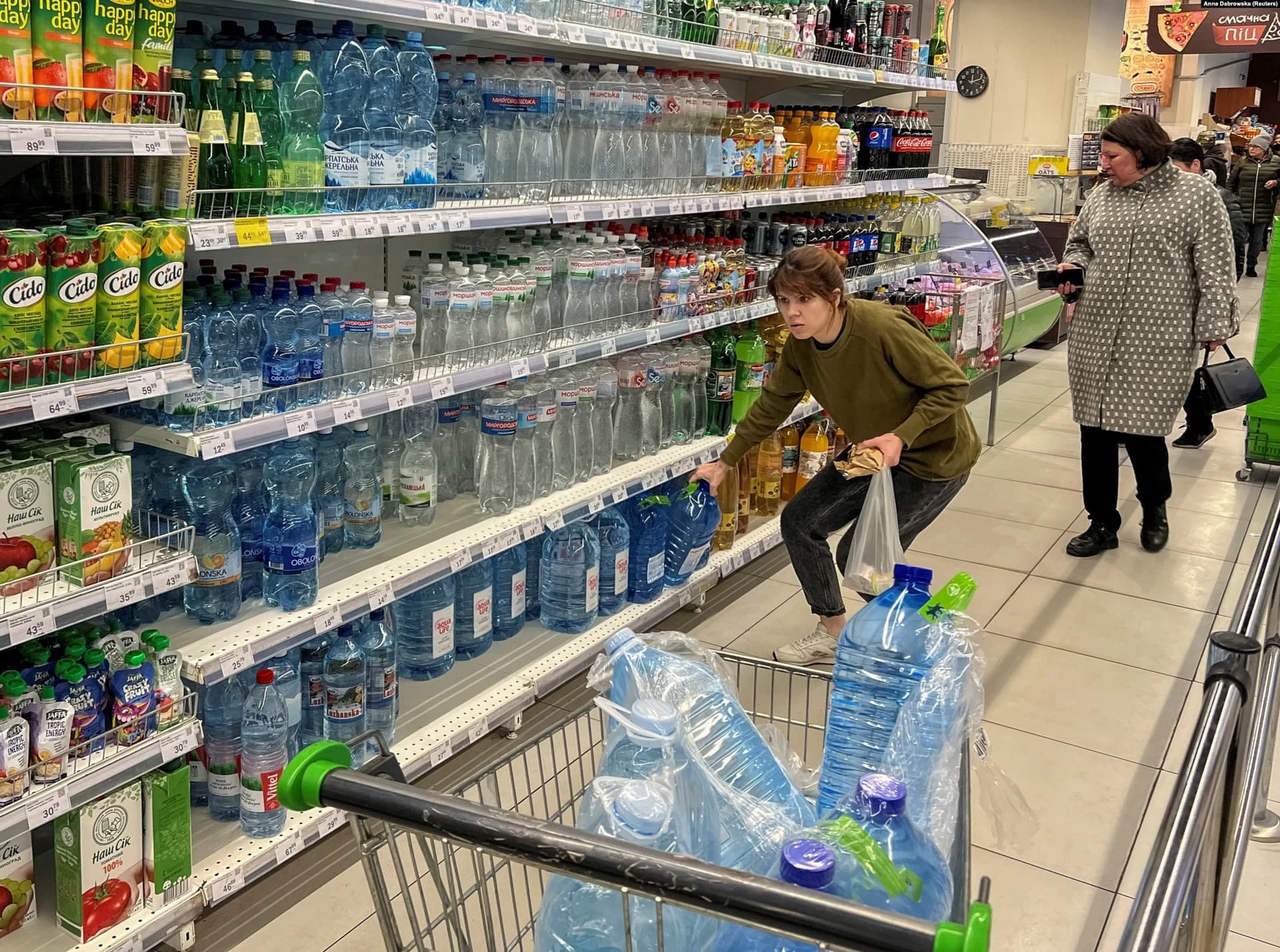 A woman stocks up on water in a store in Kyiv
