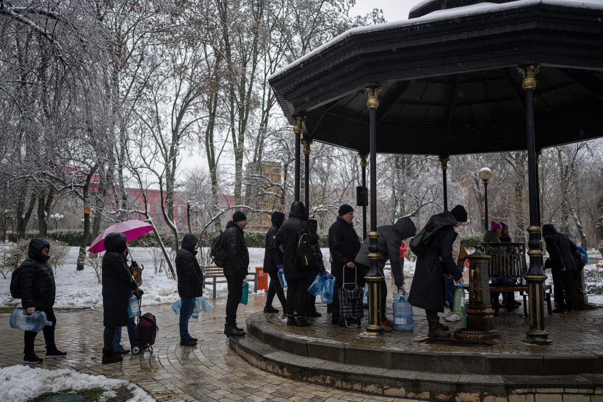 People wait in line to collect water, in Kyiv