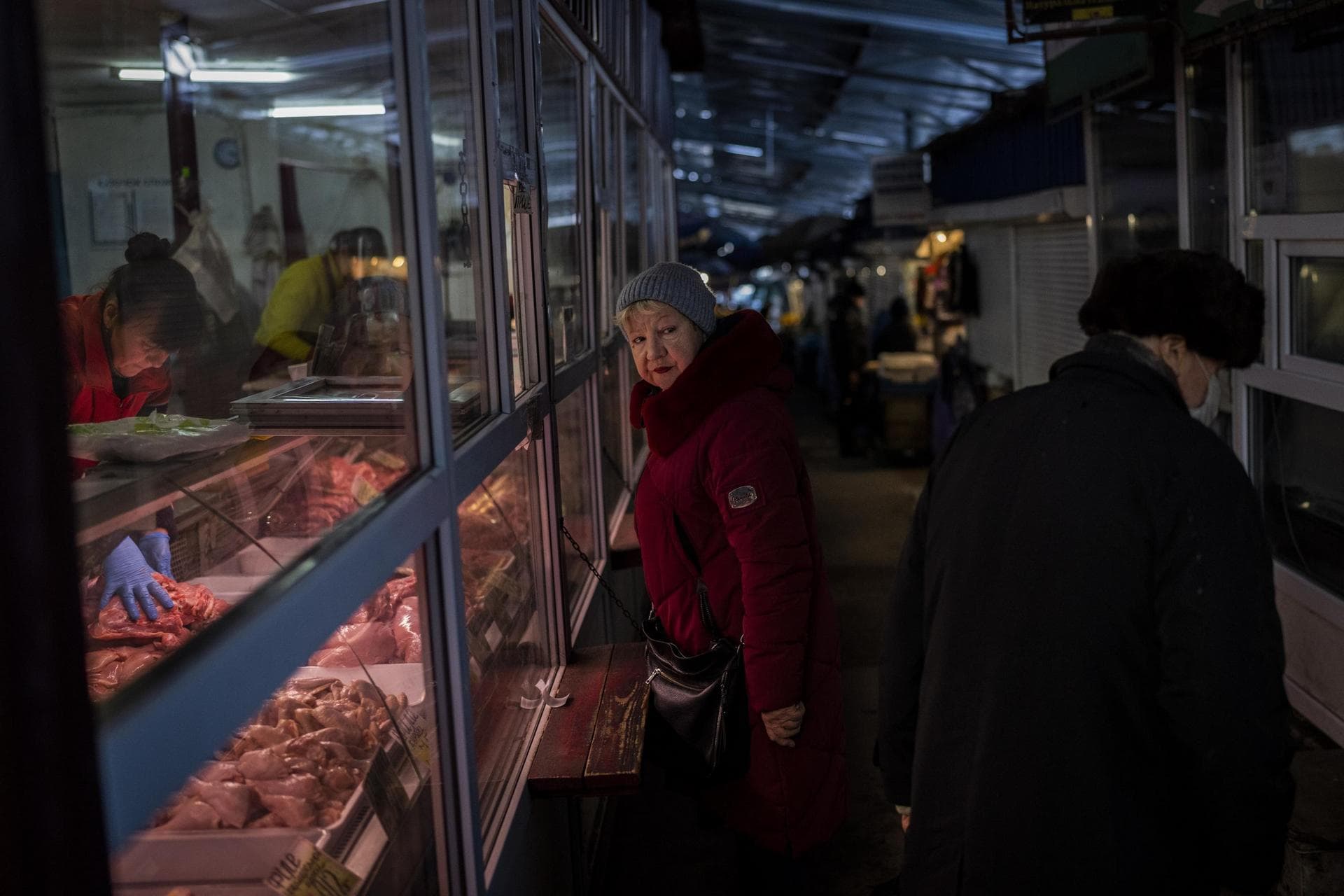 A woman buys meat inside a local market in Kyiv