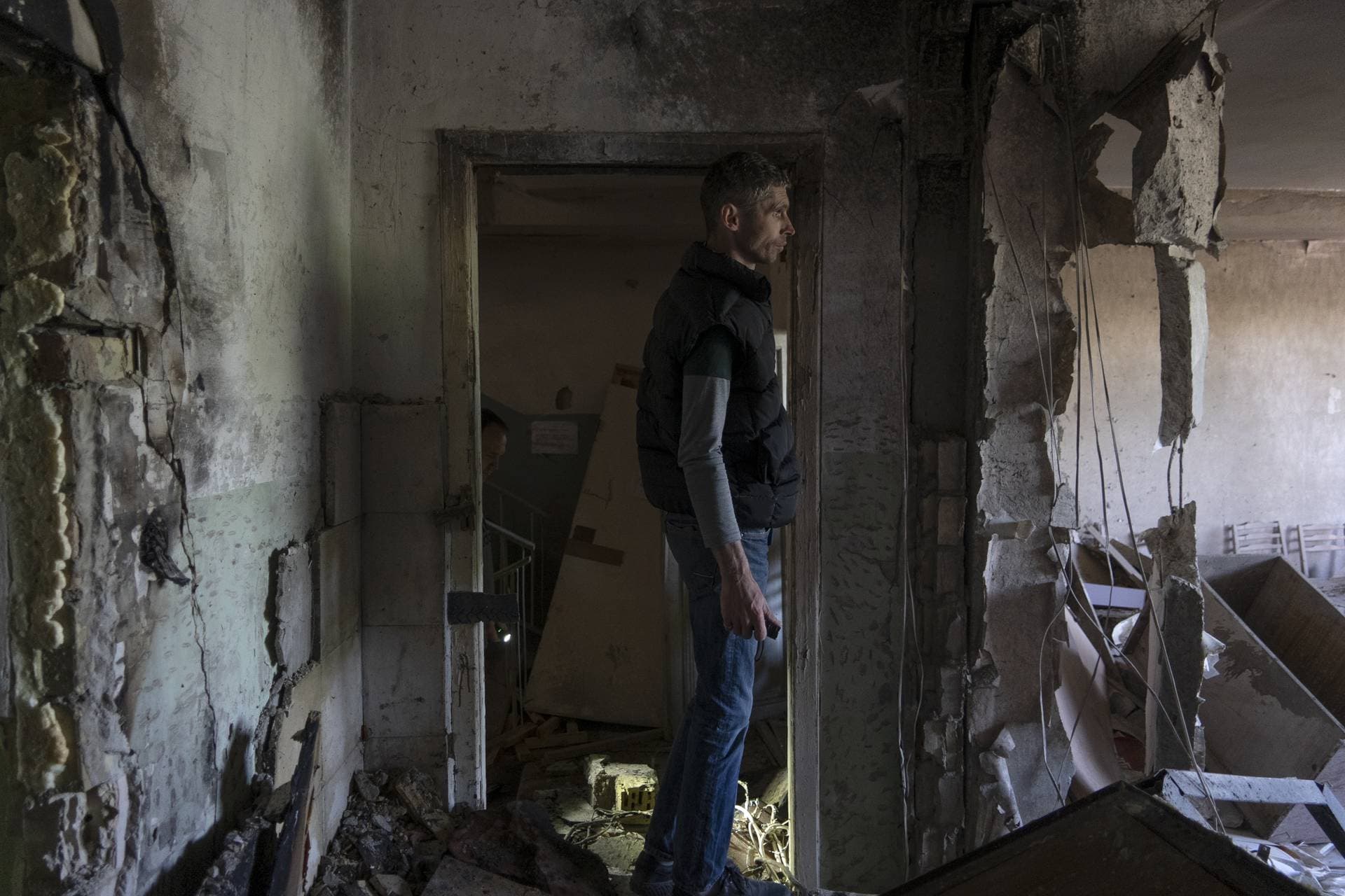 A man inspects his office damaged by a drone during a night attack, in Kyiv
