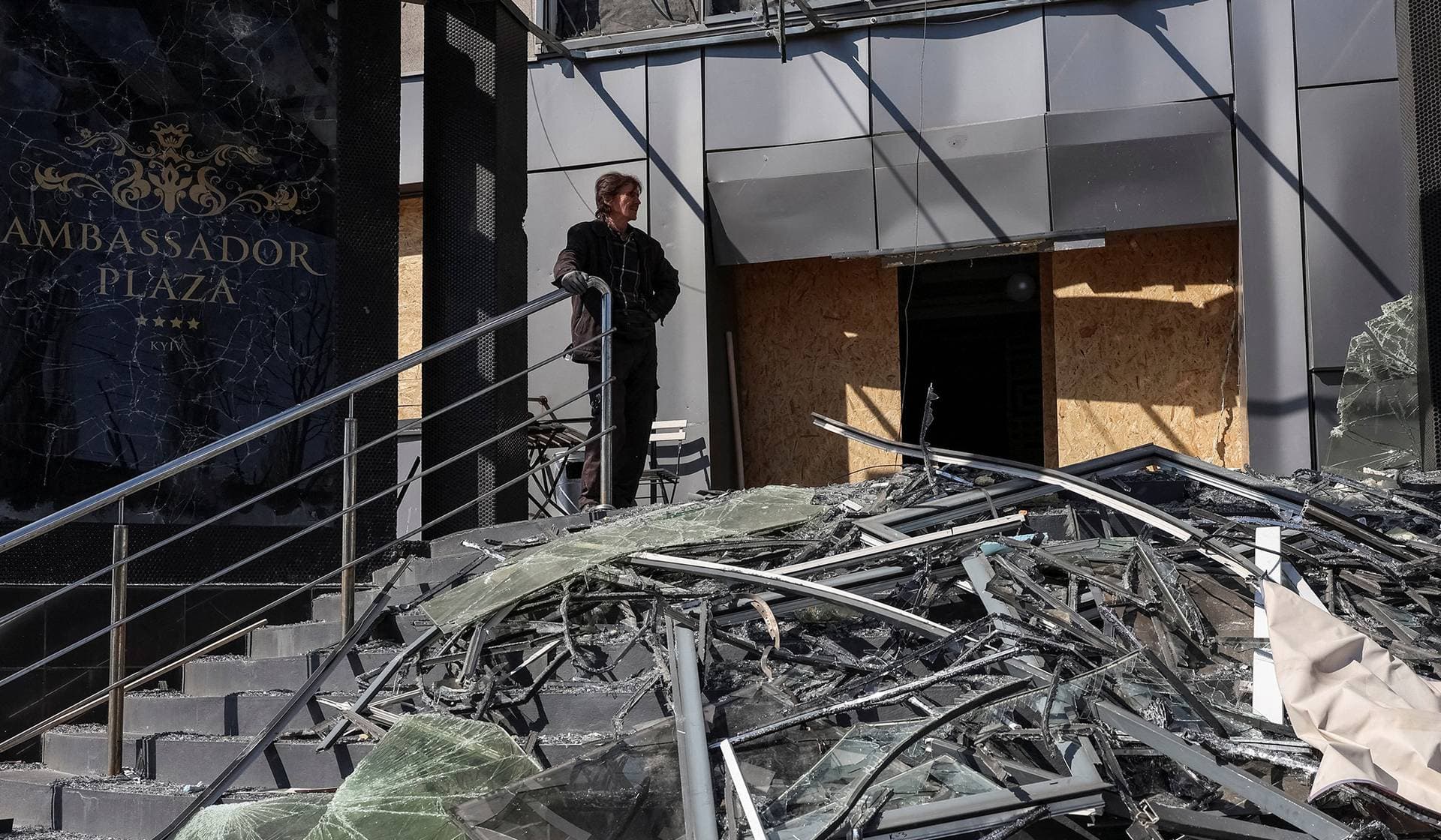 A man stands near a hotel hit by a Russian missile and drone strike in Kyiv