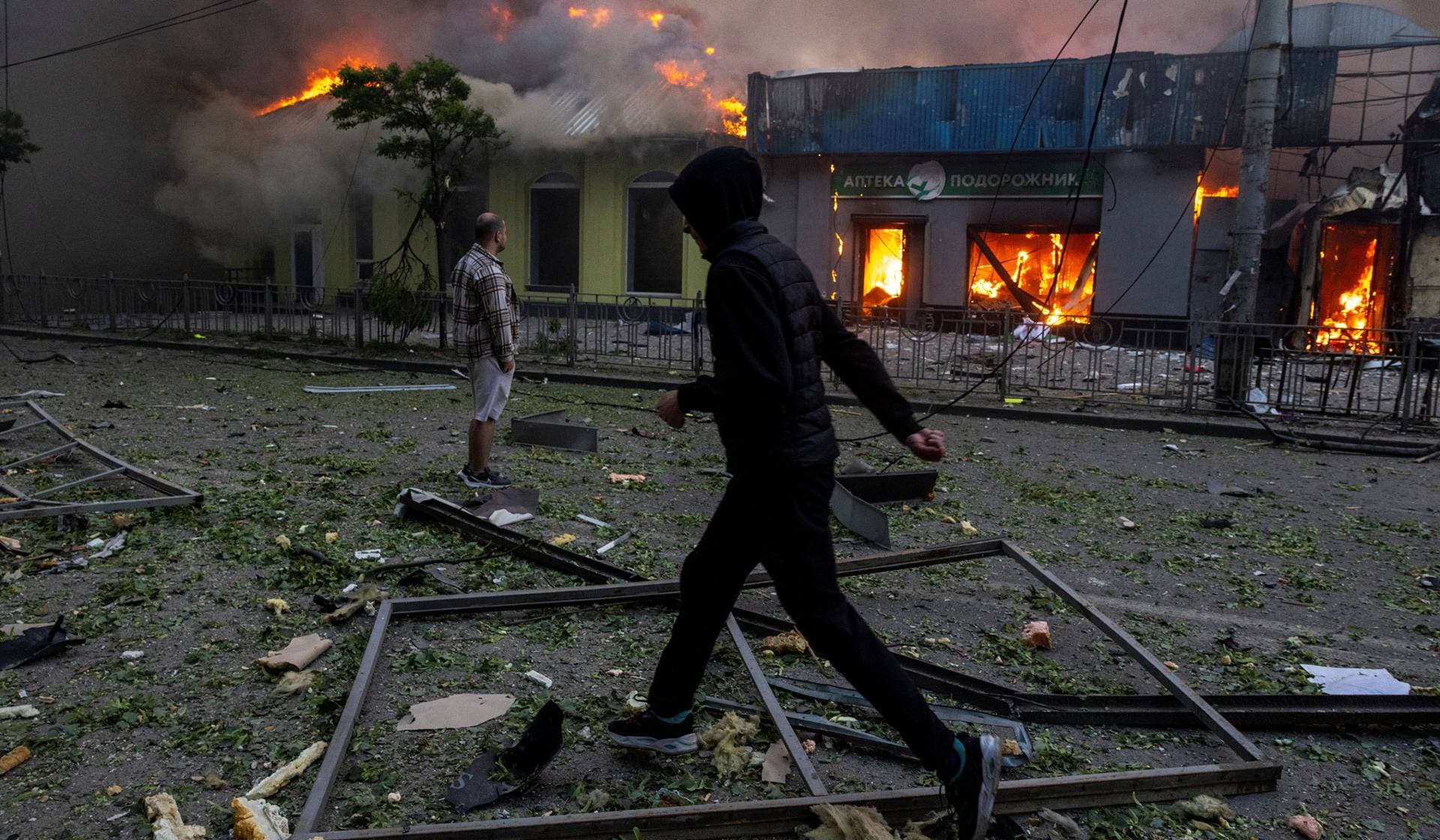 A man looks at a burning building set ablaze during an overnight Russian missile and drone strike in Kyiv