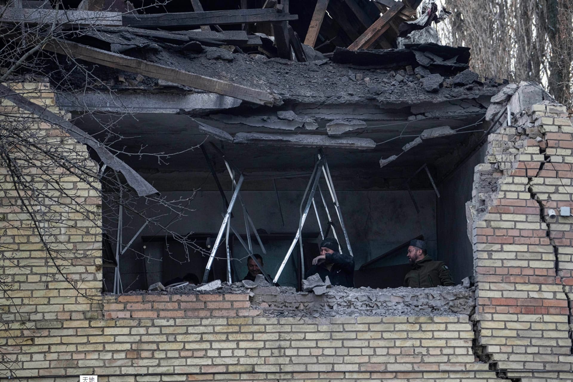 People check a tax office building, that was heavily damaged in Russian shelling, in Kyiv