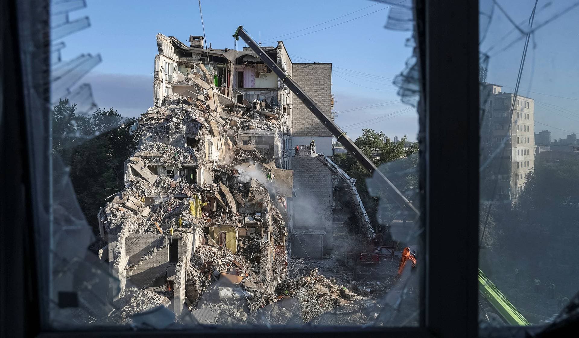 Firefighters work at the site of an apartment building damaged during a Russian missile and drone strike in Kyiv
