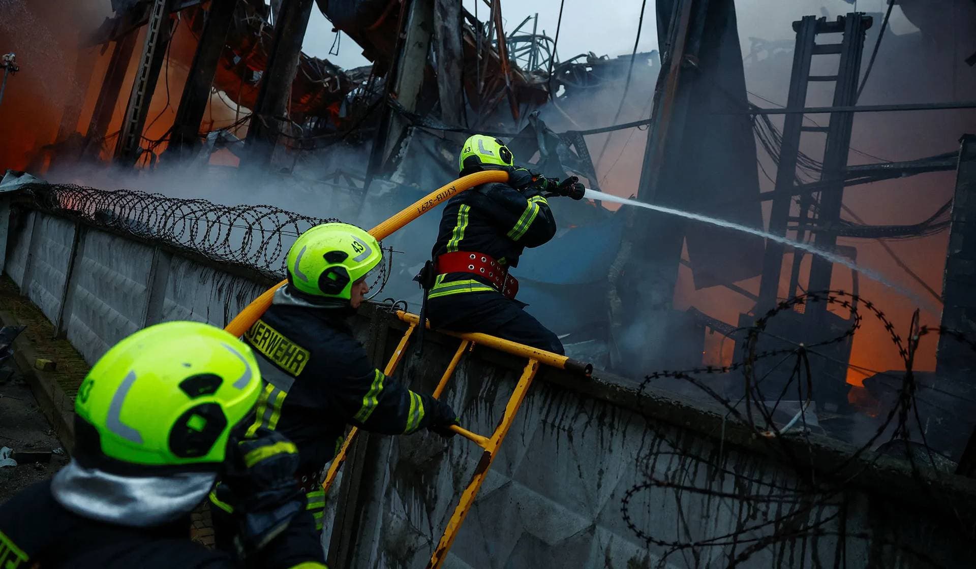 Firefighters work at the site of food warehouses hit by an overnight Russian missile strike in Kyiv