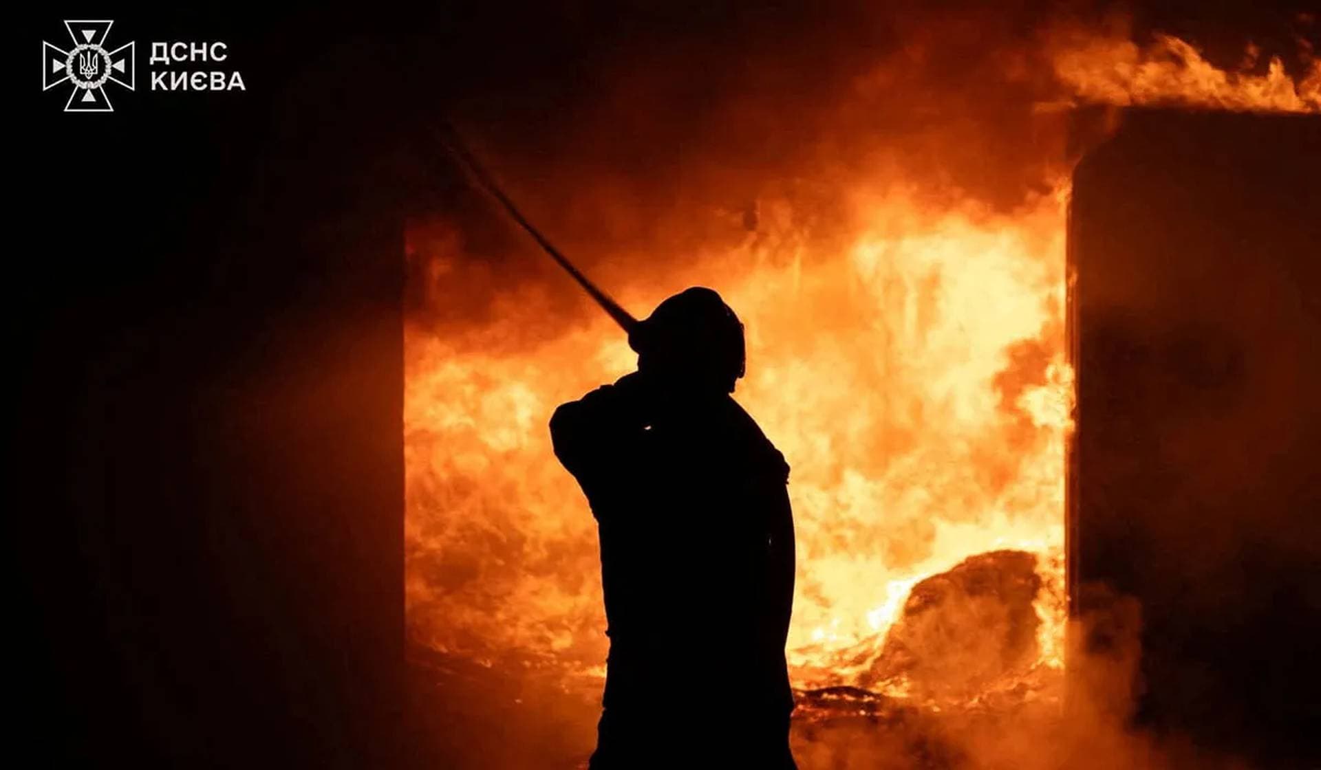 A firefighter works at a site of a Russian strike in a location given as Kyiv