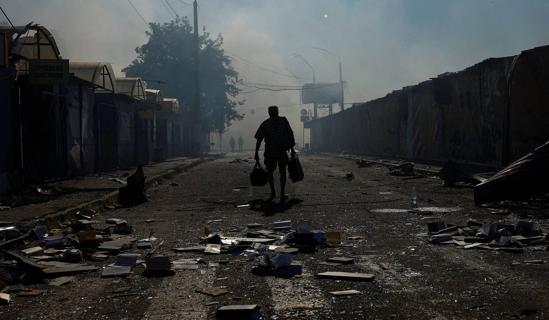 A resident walks at the site of a book market hit by a Russian missile strike in Kyiv