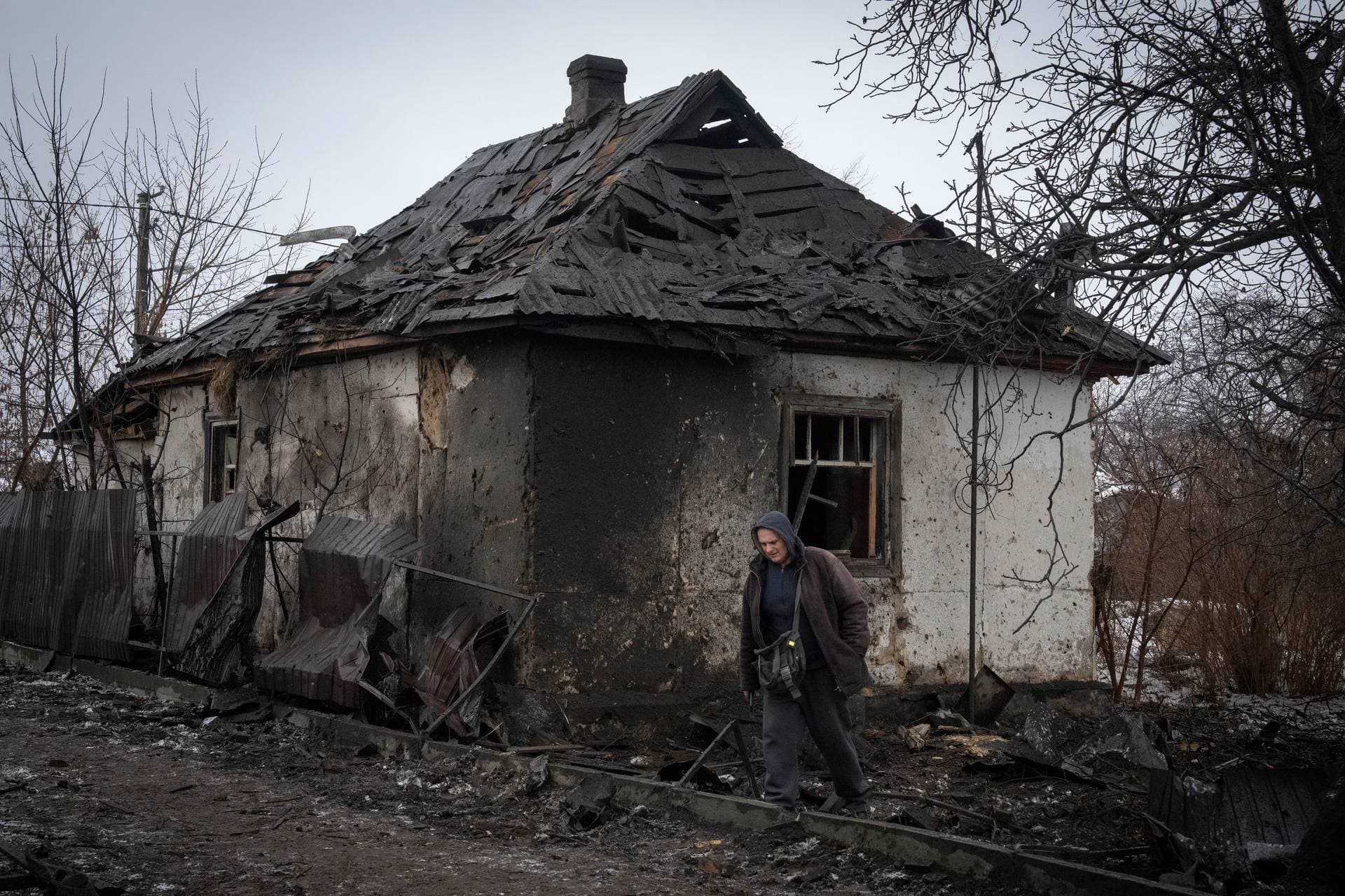 A local resident passes by a private house damaged in the Russian missile attack in Kyiv